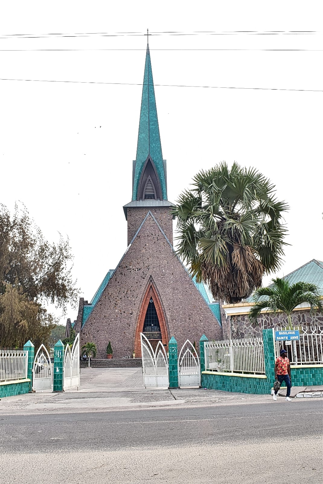 A church with a distinctive green striped tiled roof and modernist design