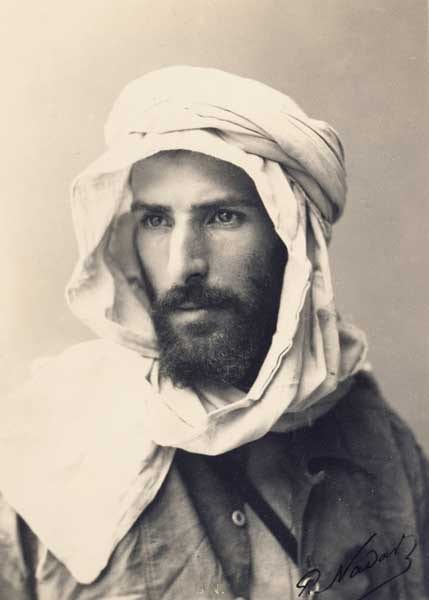 A studio portrait of the bearded explorer Pierre Savorgnan de Brazza in a light suit