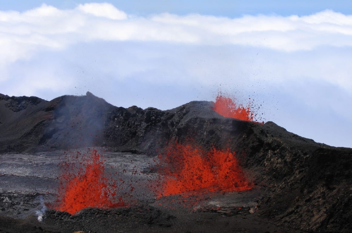 Glowing orange lava erupting from a fissure on a volcanic mountainside