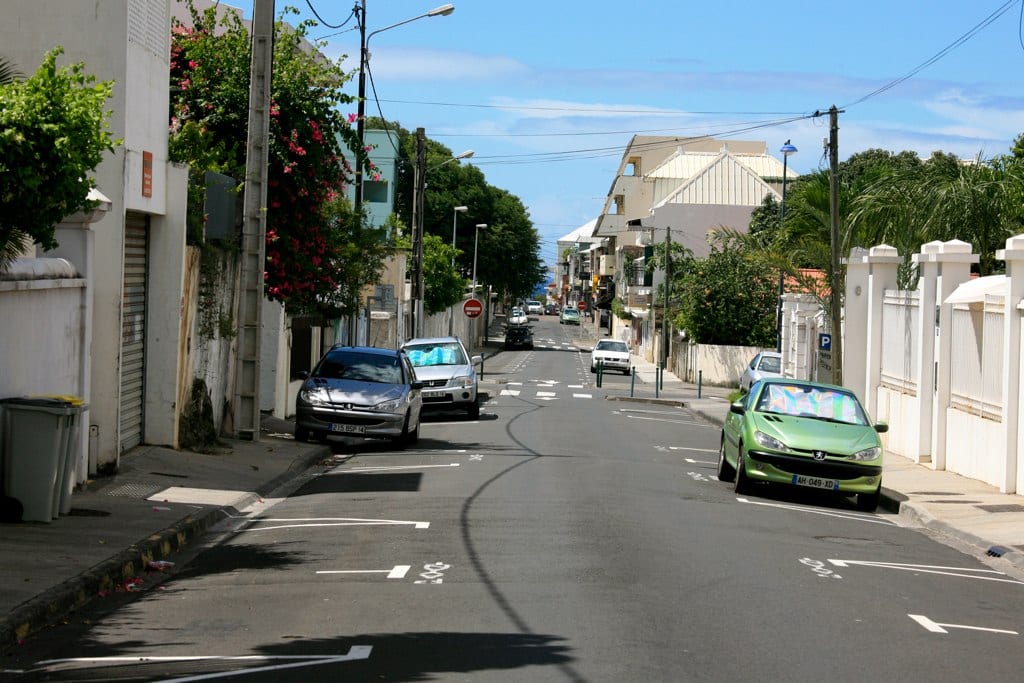 A tropical coastal city street with colonial-era buildings