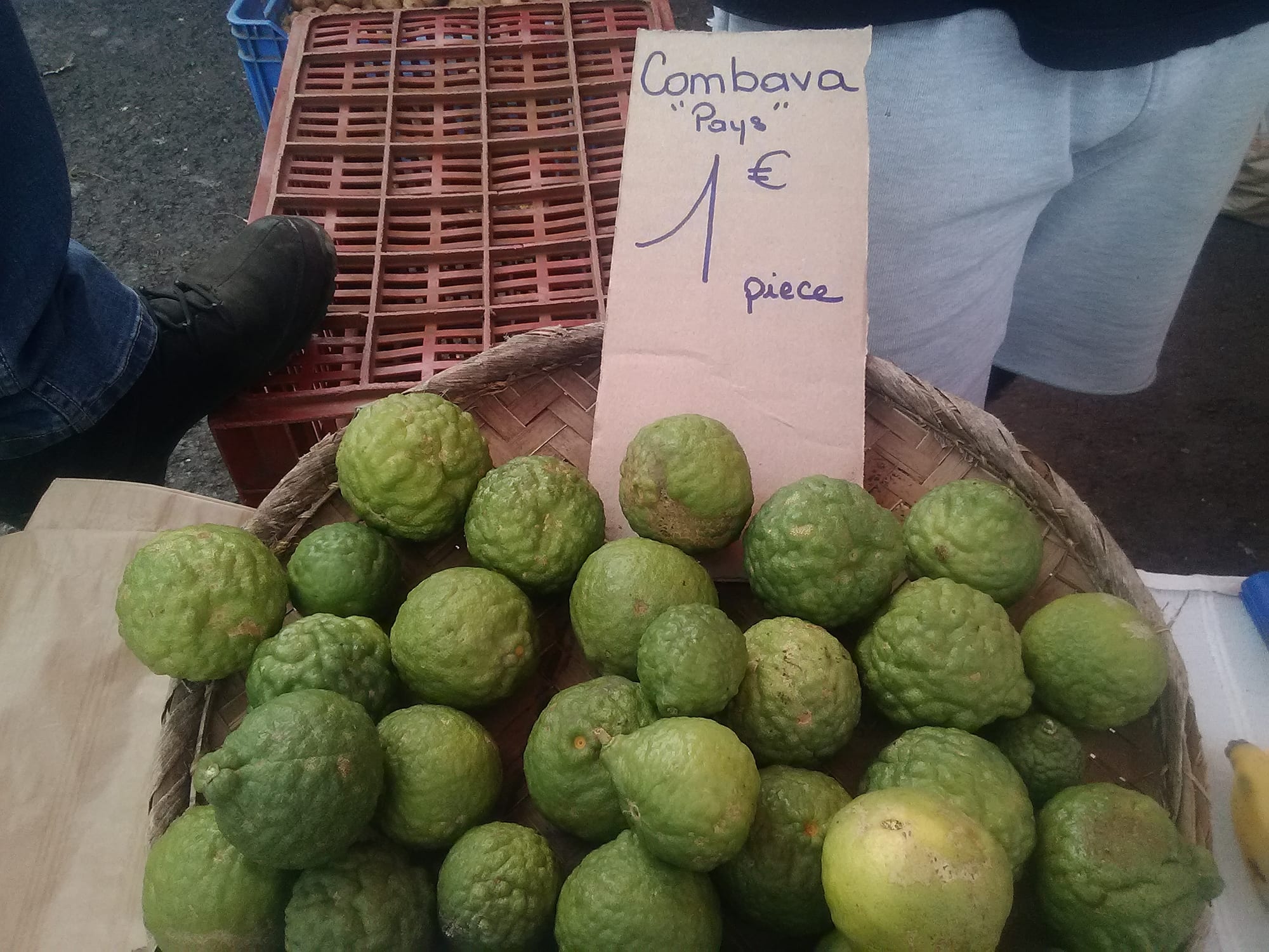 Small green citrus fruit for sale at a market stall