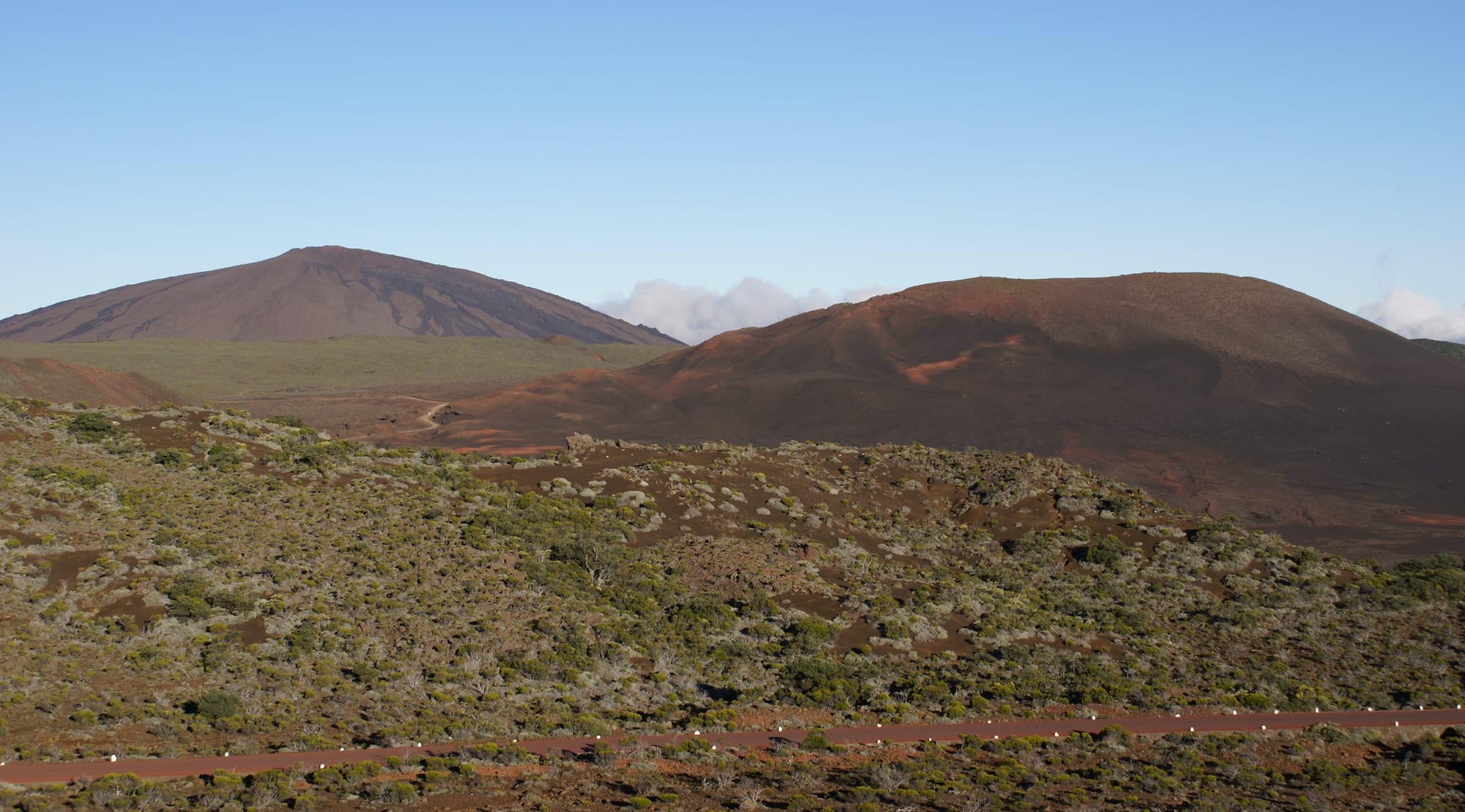 A vast dark lava field and cinder cones inside the caldera of the Piton de la Fournaise volcano on Réunion