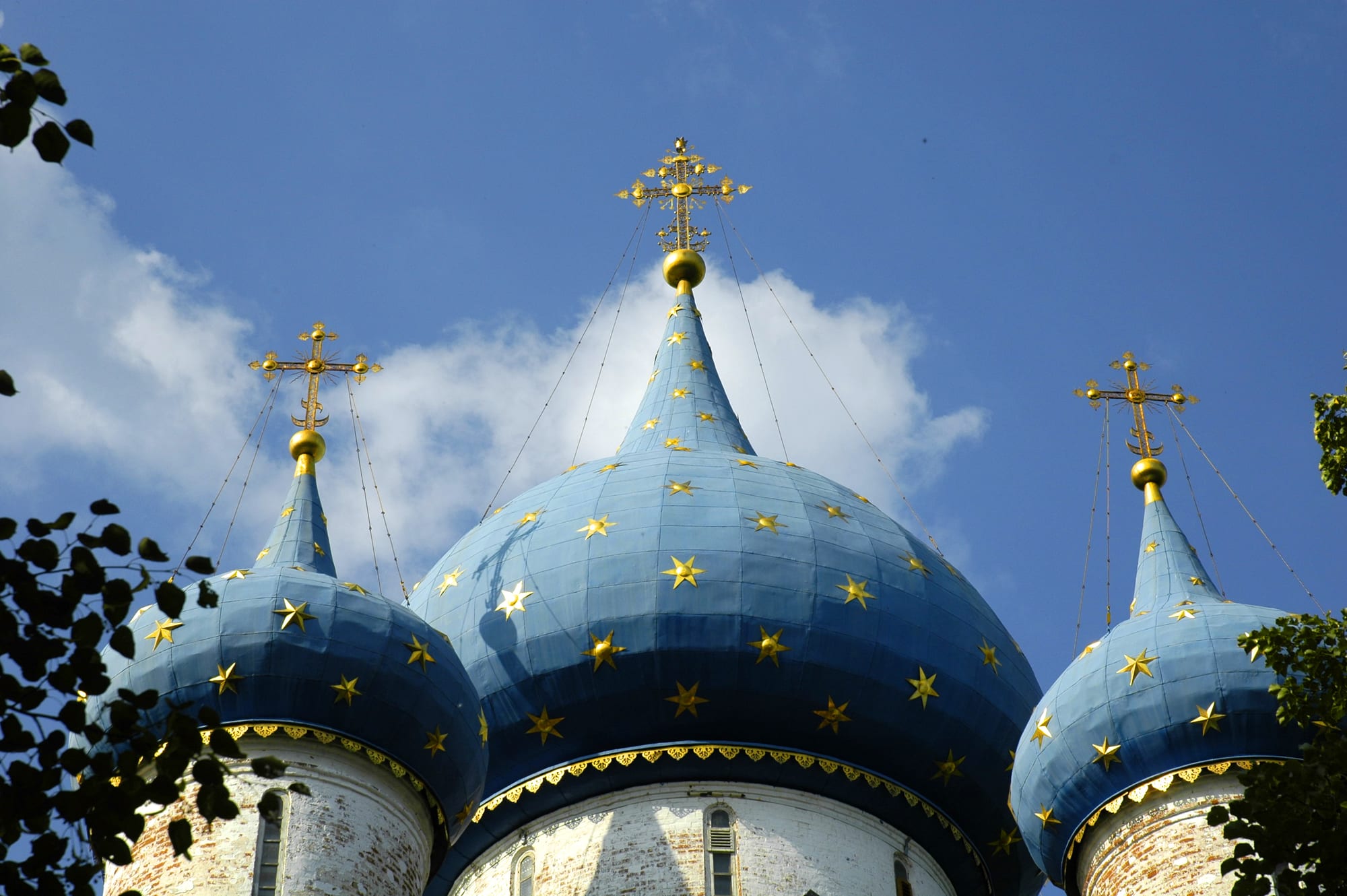 A white stone cathedral with blue domes covered in gold stars