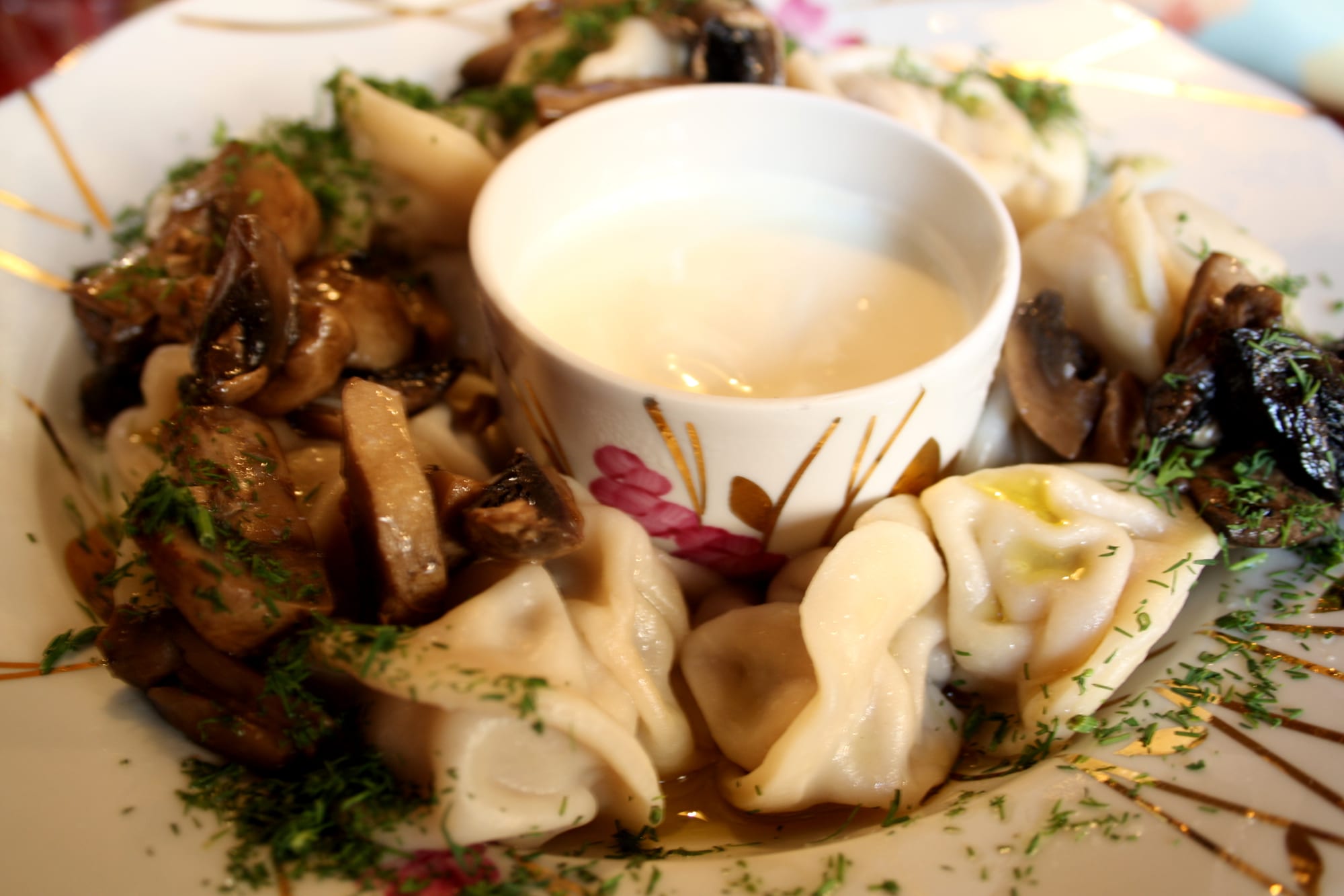 A bowl of dumplings with mushrooms and sour cream
