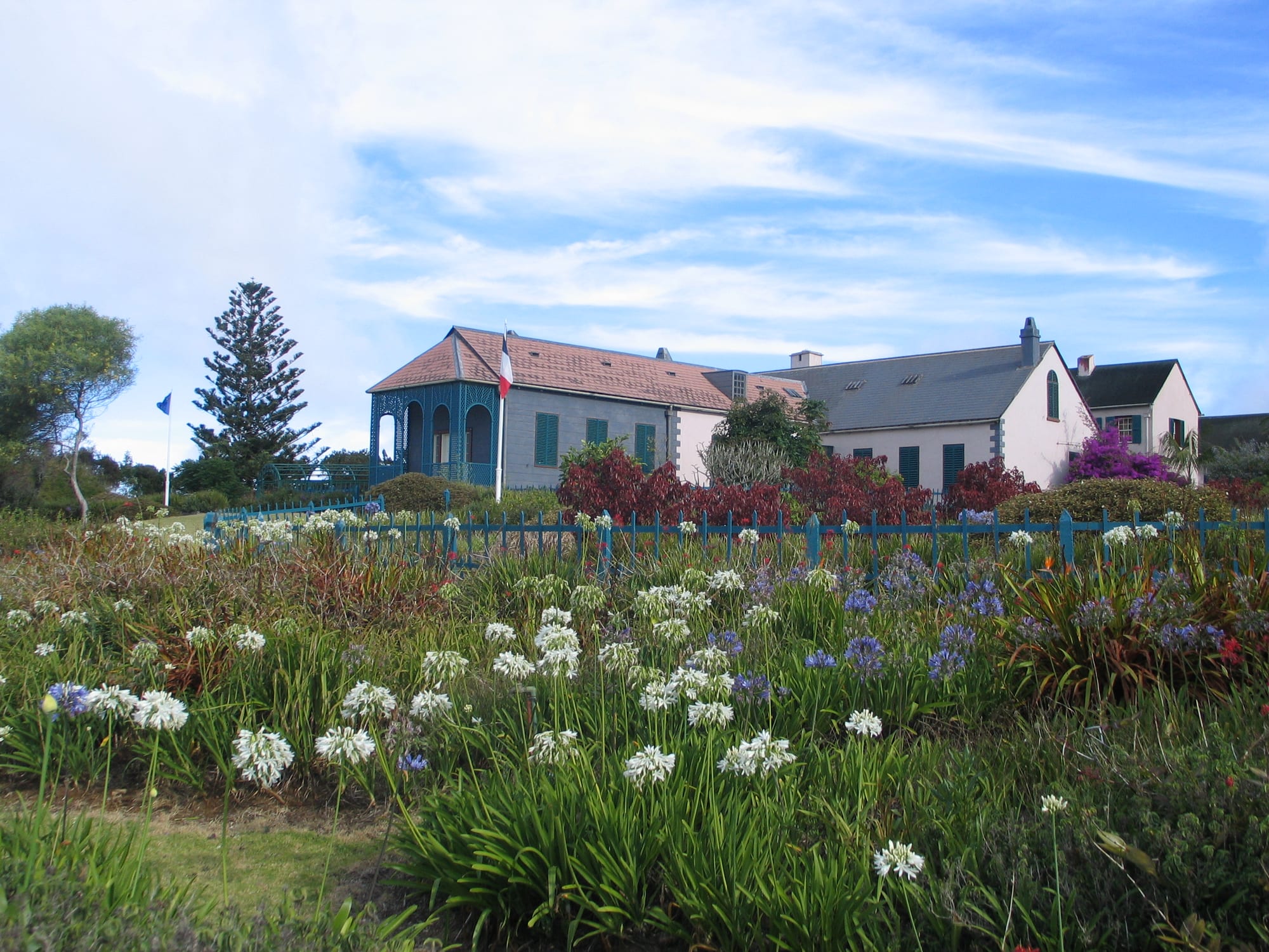 A modest colonial-era house surrounded by gardens
