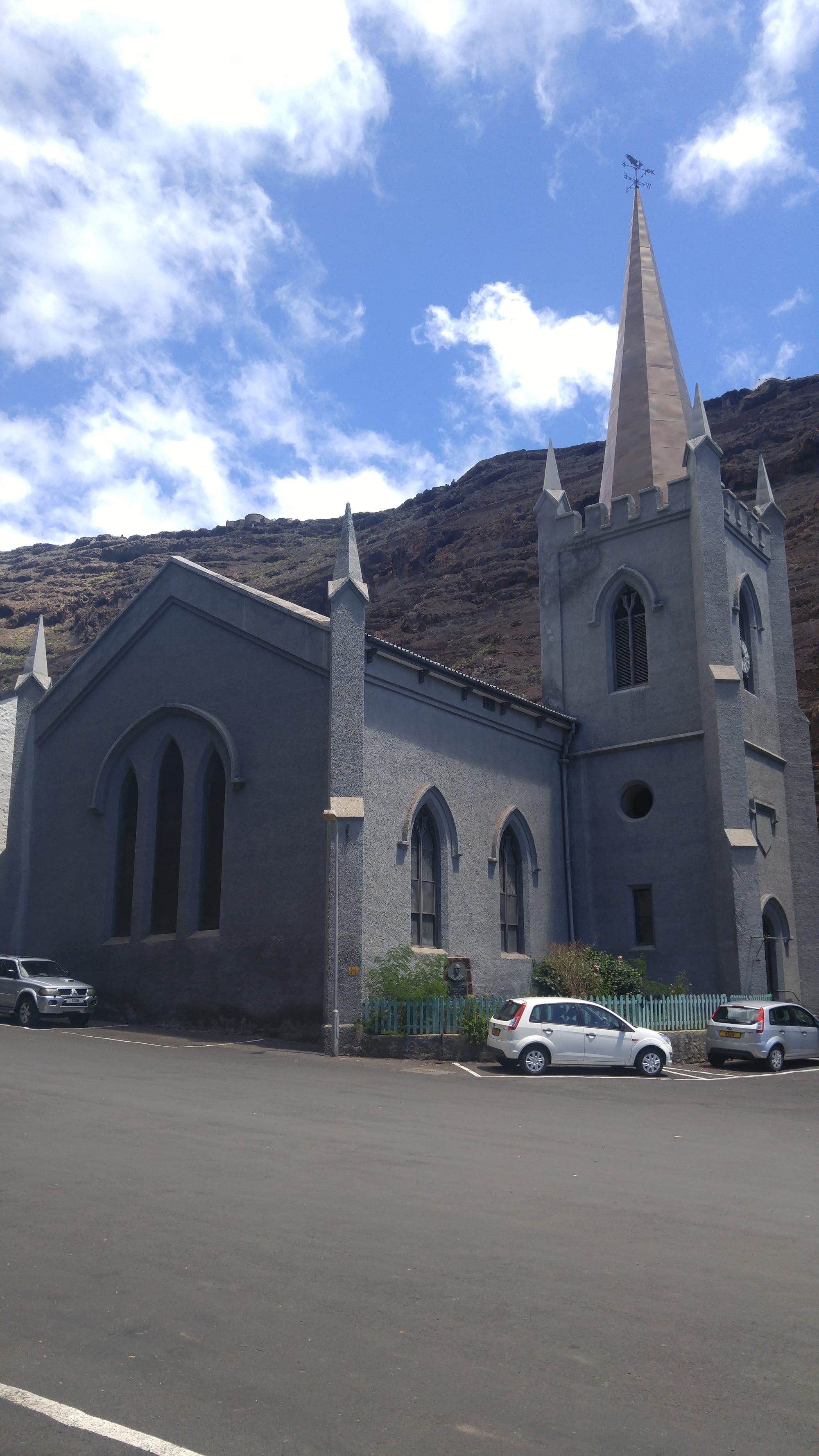 A historic stone church on a narrow street lined with colonial-era buildings