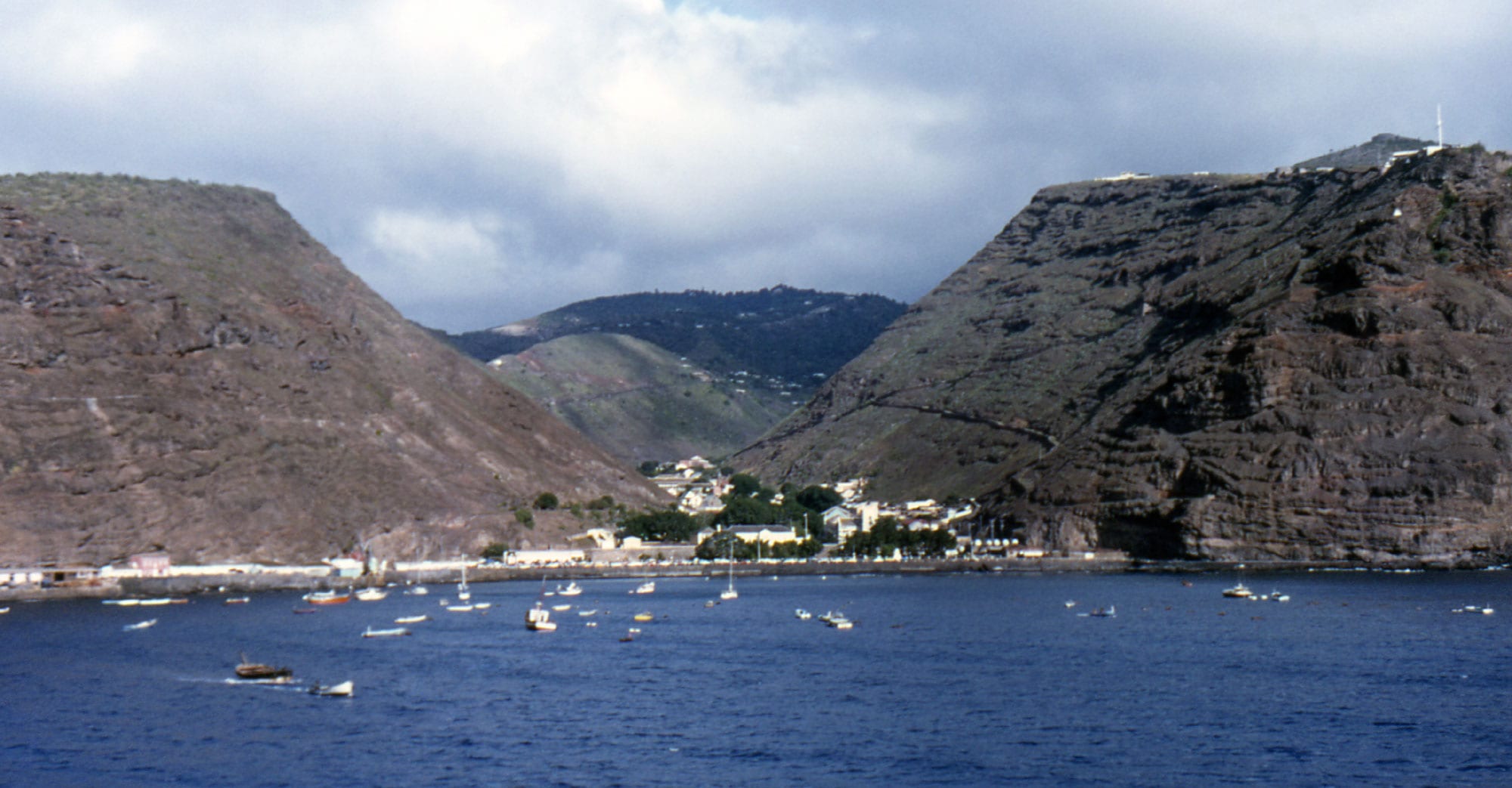 A narrow town squeezed into a steep volcanic valley leading down to the sea