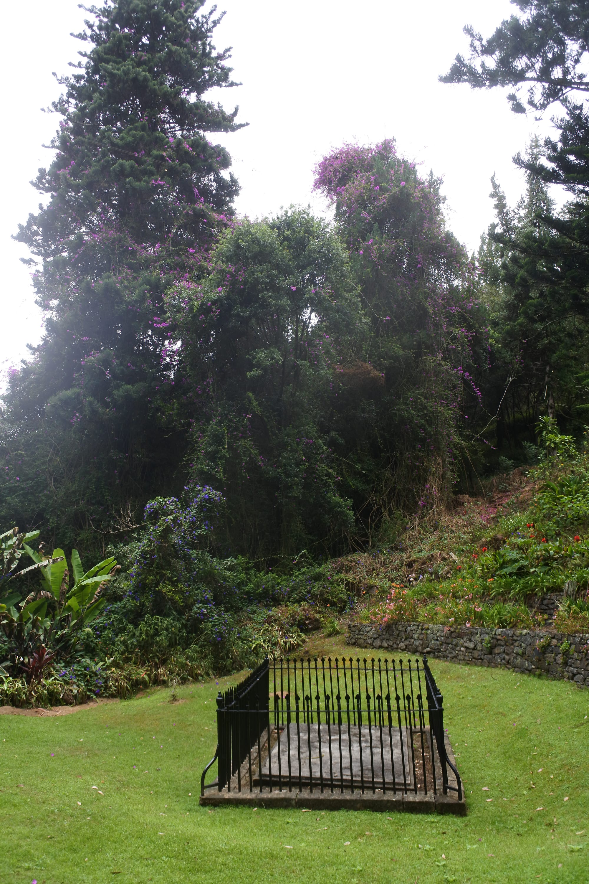 A plain stone tomb enclosure in a quiet valley setting