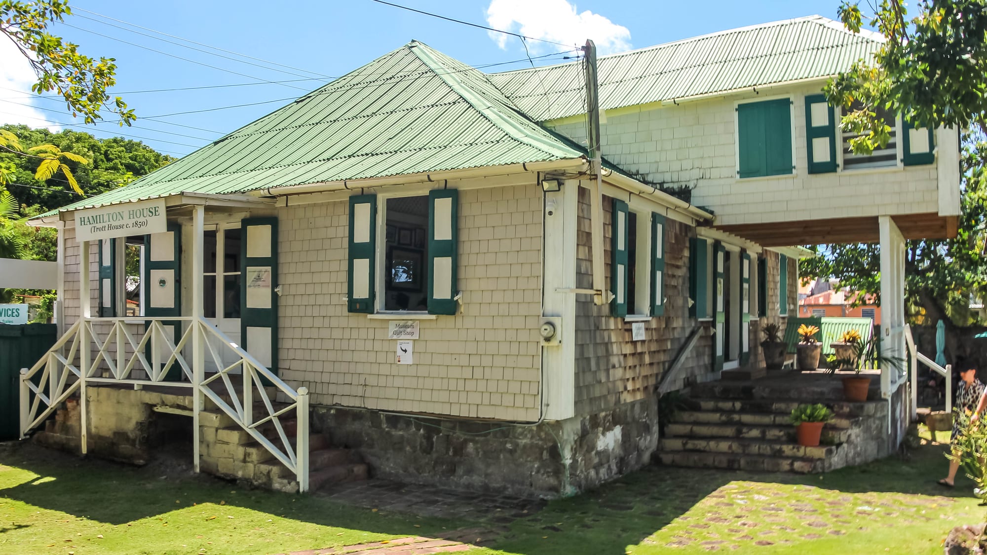 A colonial-era wooden building with a green roof, signed 'Hamilton House'