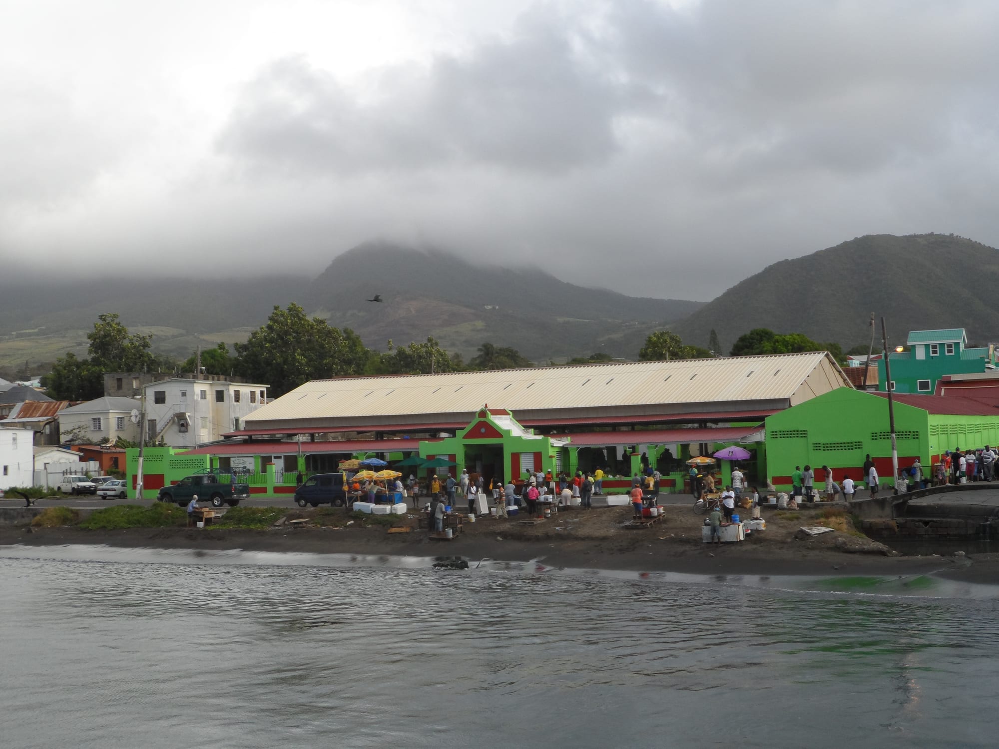 An outdoor market with vendors and produce stalls