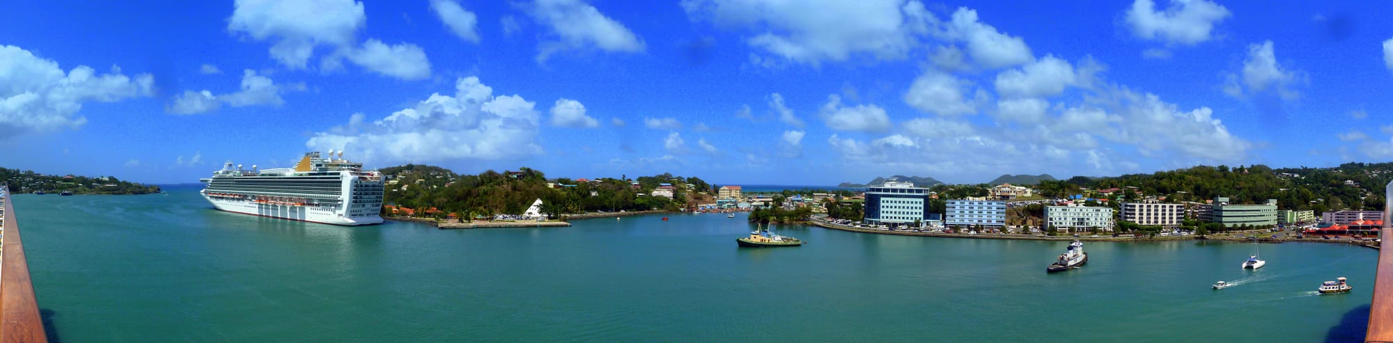 A harbour town with buildings along the waterfront and hills behind
