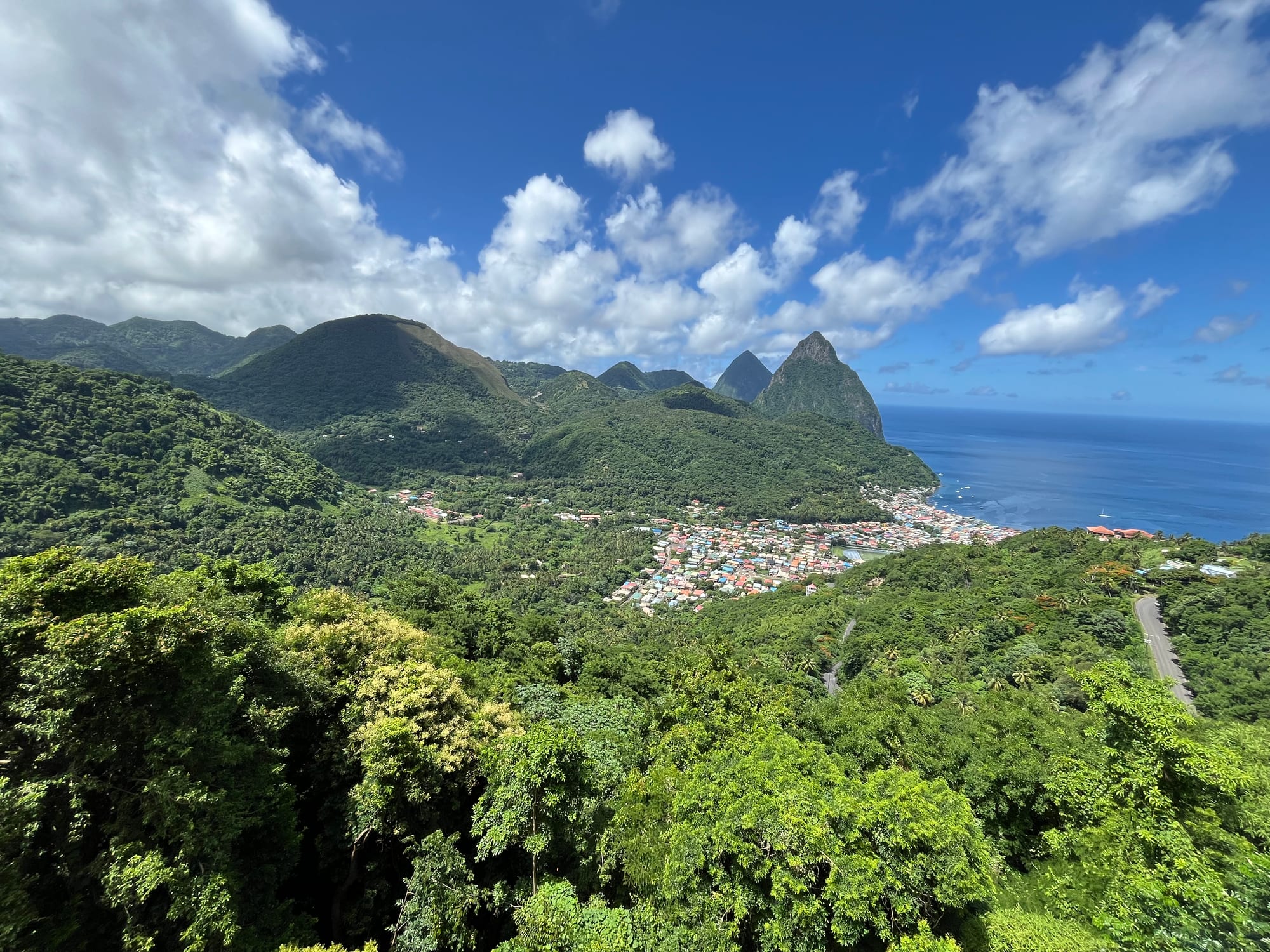 Two steep forested volcanic spires rising straight out of the sea beside the small town of Soufrière