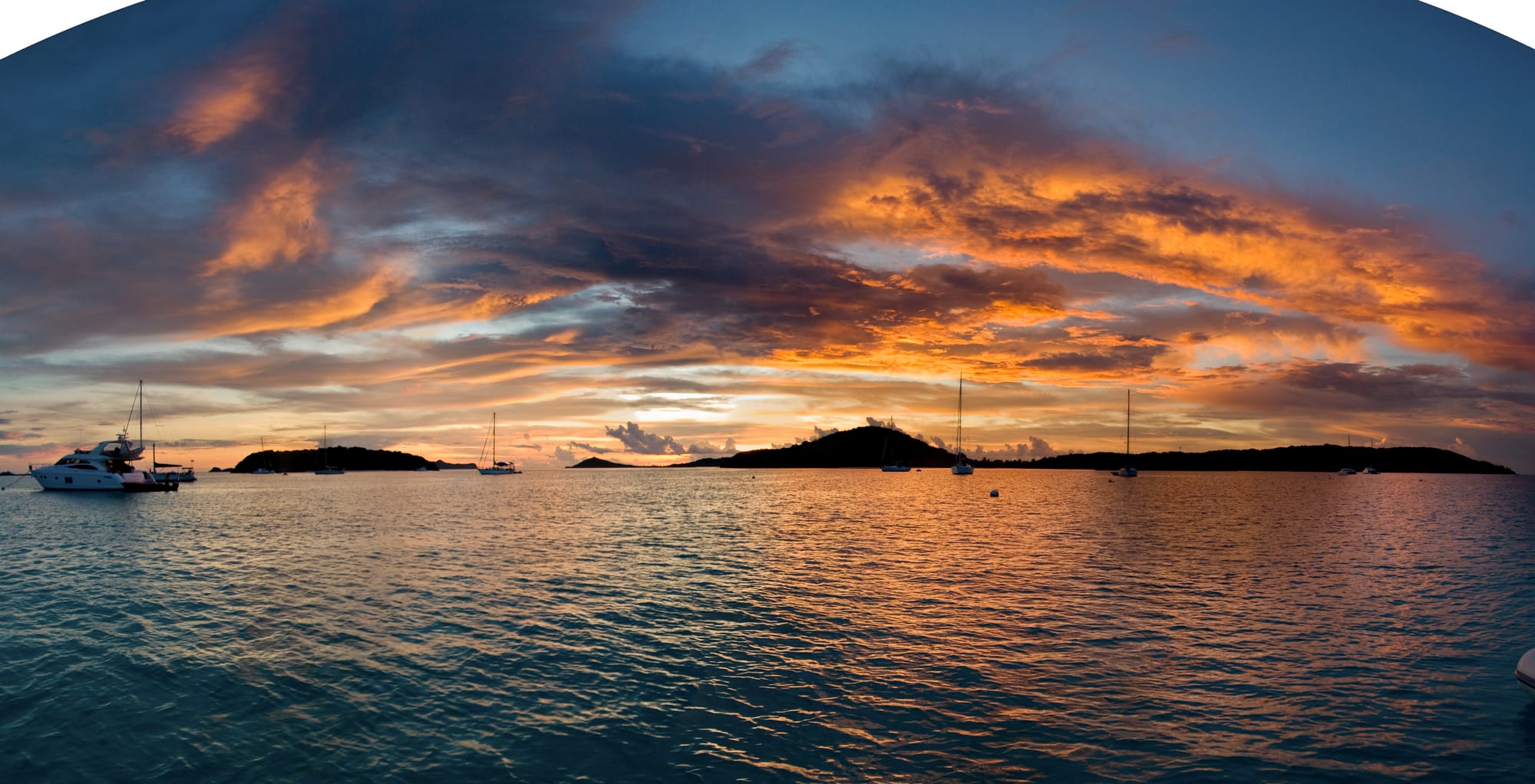 A group of small uninhabited islets in turquoise water at sunset