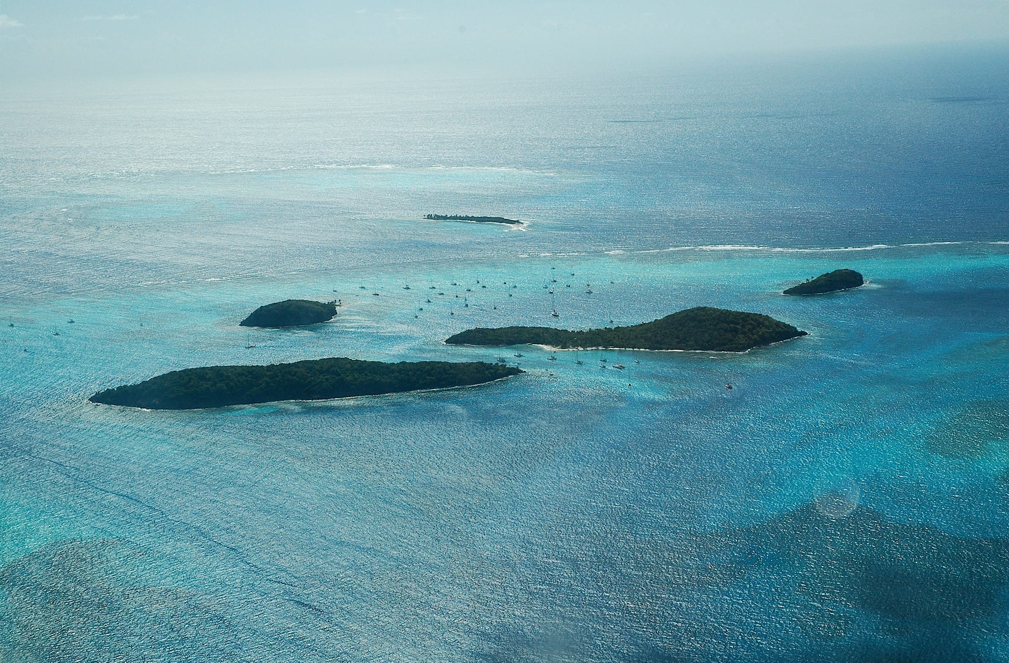A cluster of small uninhabited islands surrounded by turquoise water