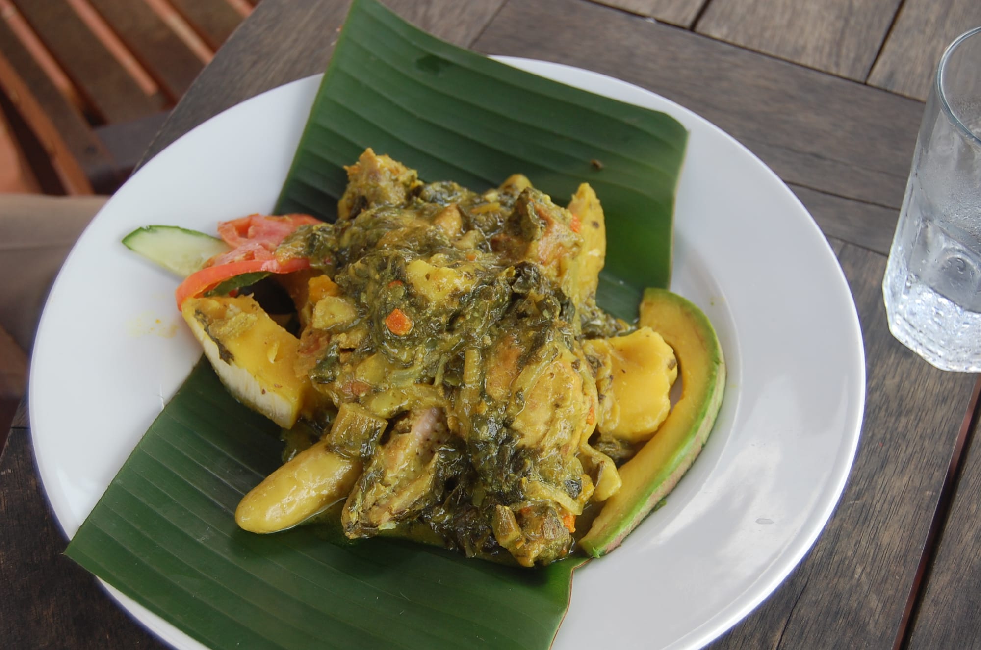 A plate of breadfruit chunks stewed with meat and greens in coconut milk