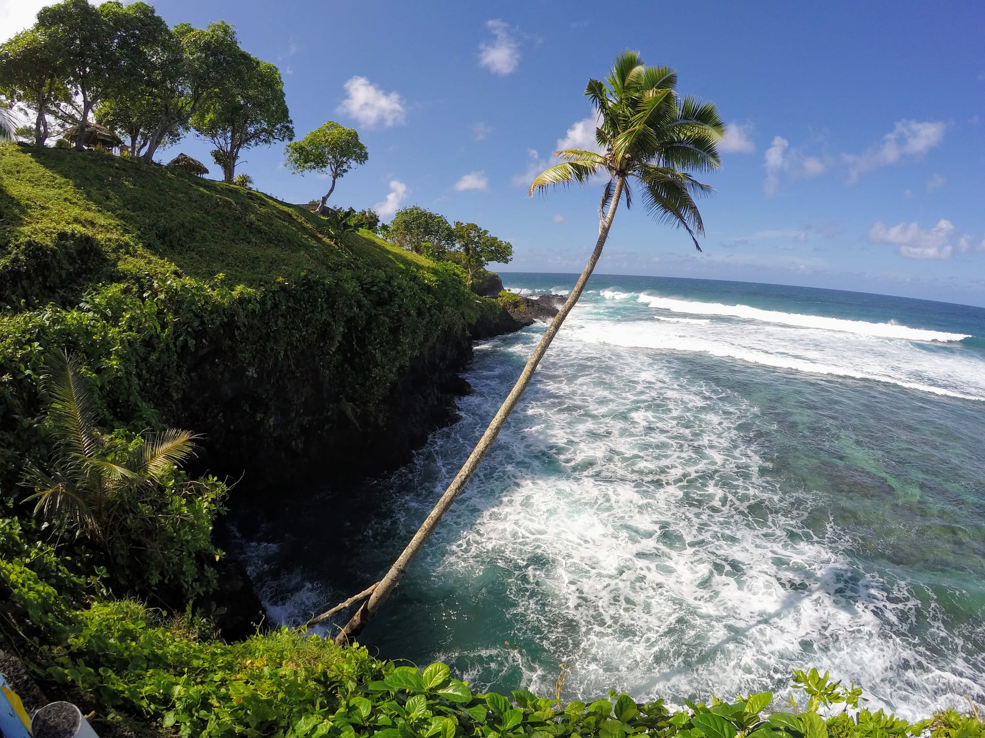 A narrow rock channel where ocean water flows into a deep circular pool