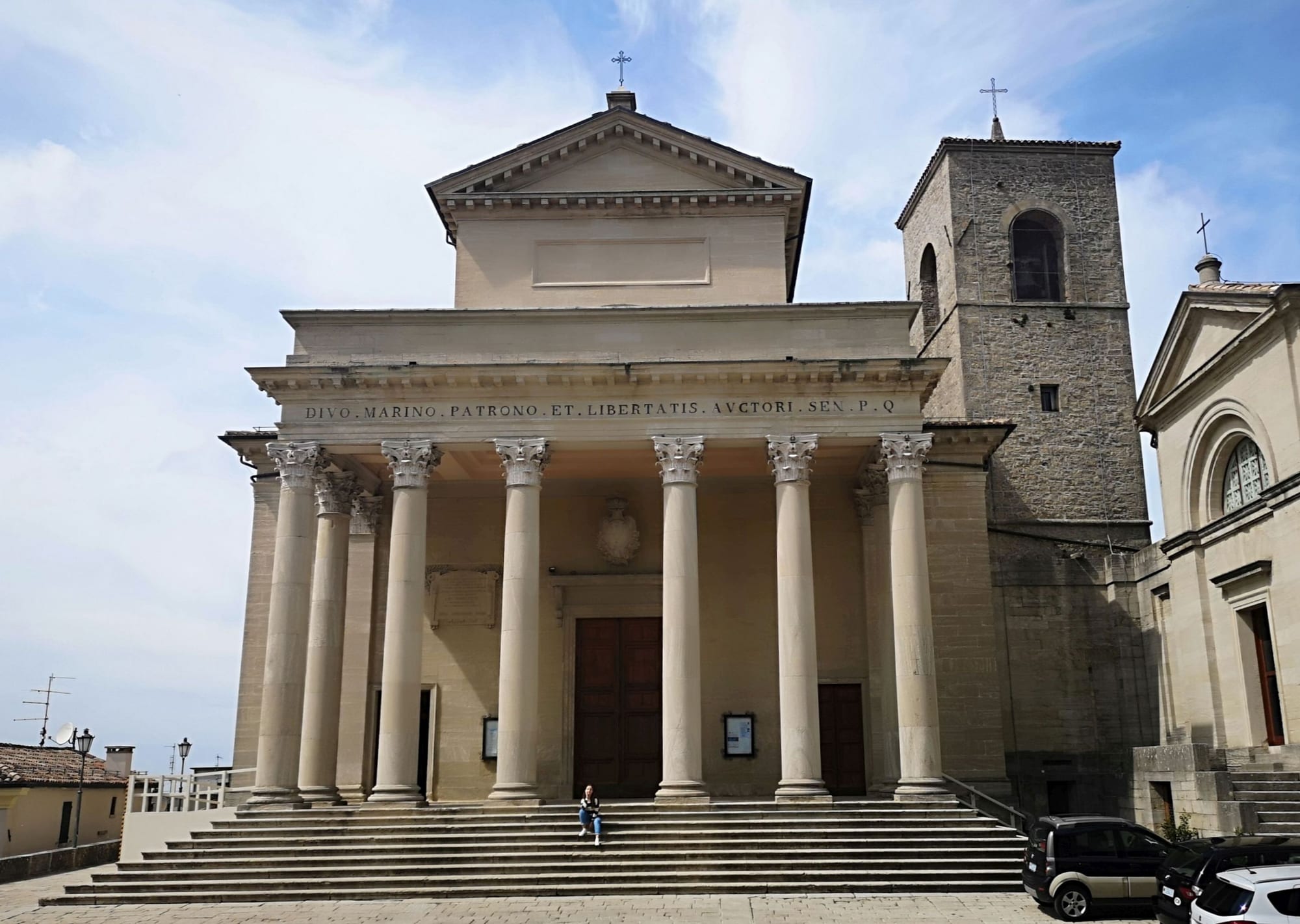 A neoclassical basilica facade with columns on a town square