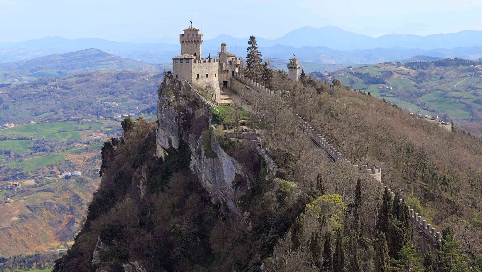 Three medieval towers strung along a rocky mountain ridge