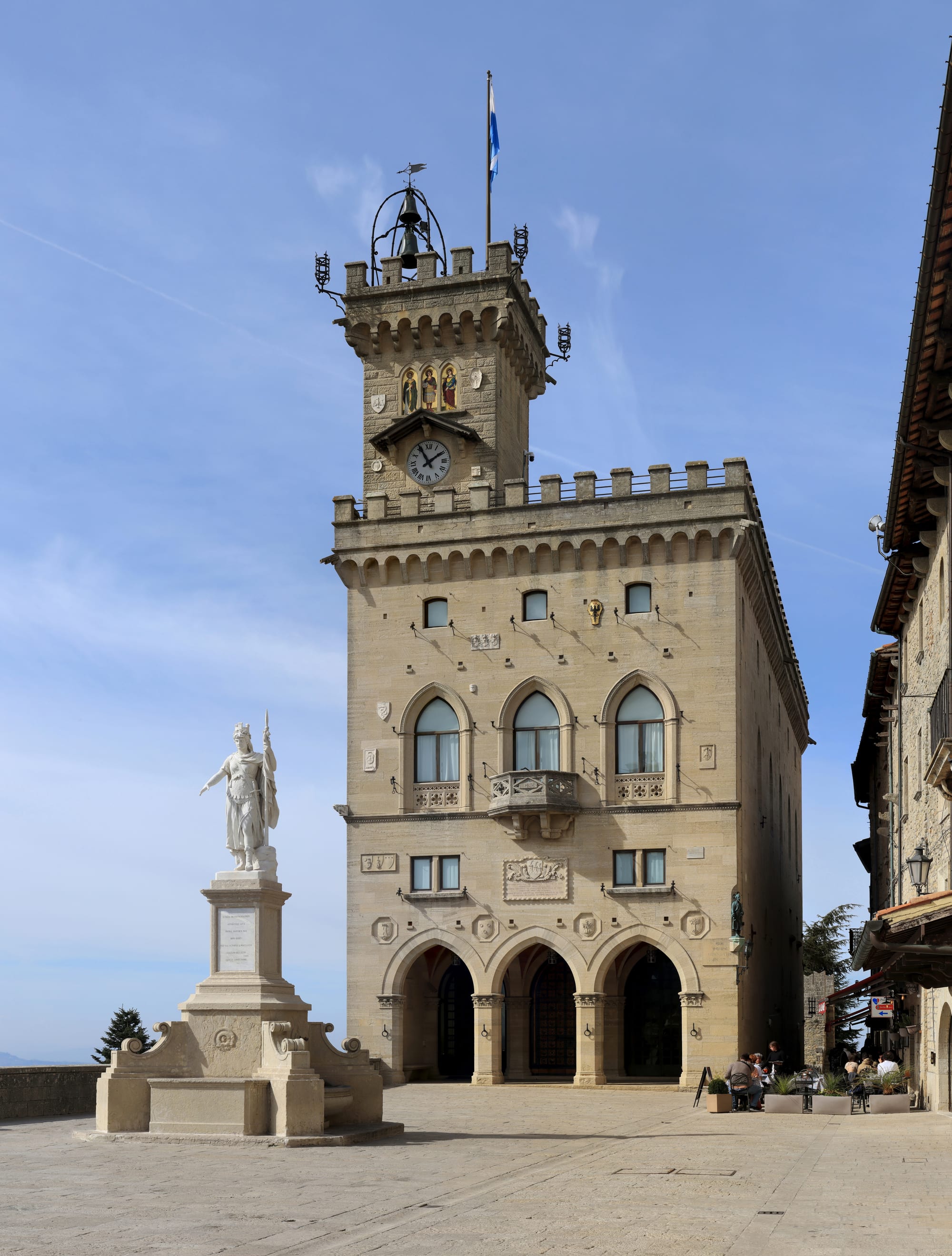 A public square with a statue and government palace