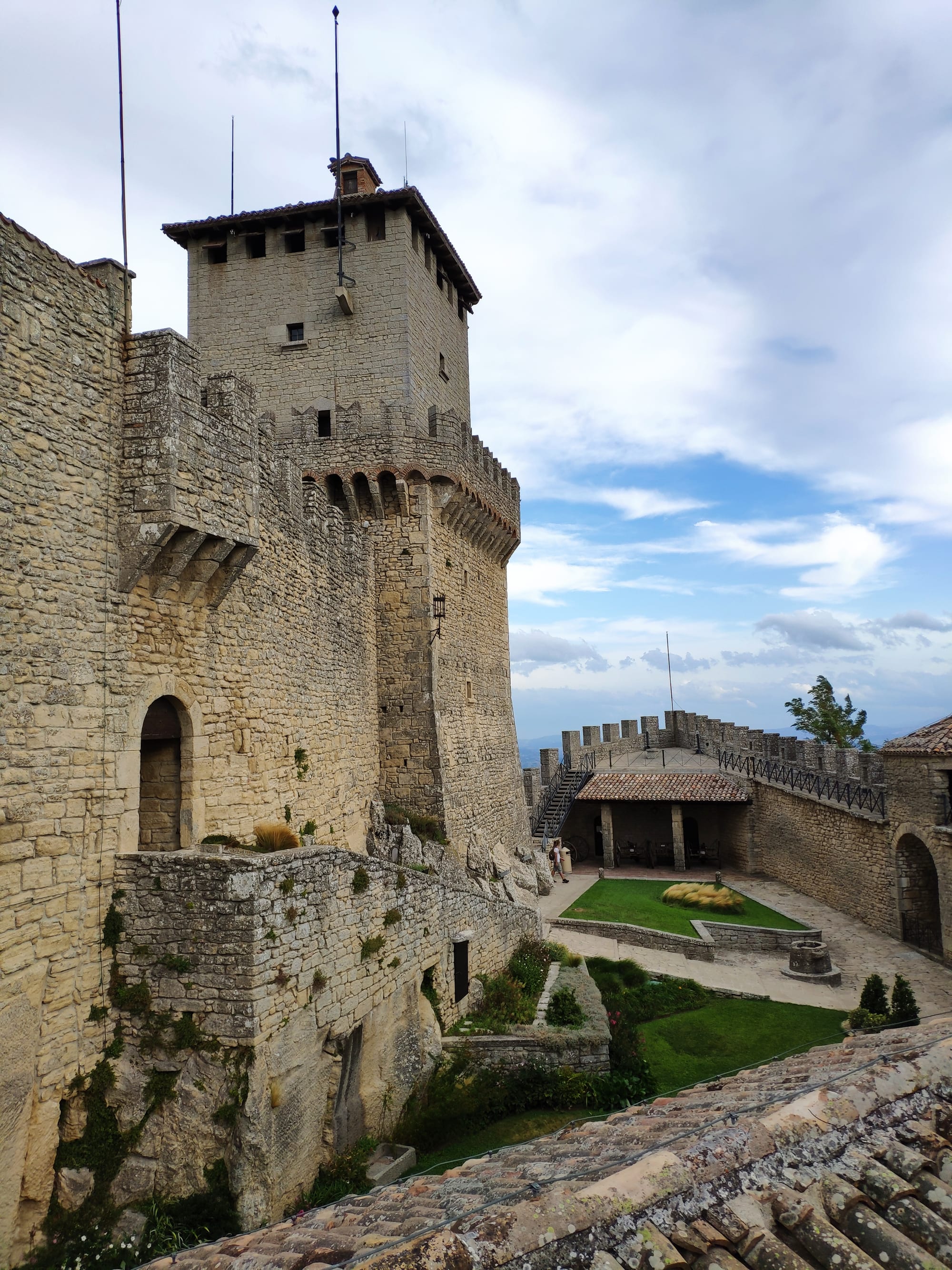 The tall stone keep of the Guaita tower rising from the rock, with battlements and a small turret