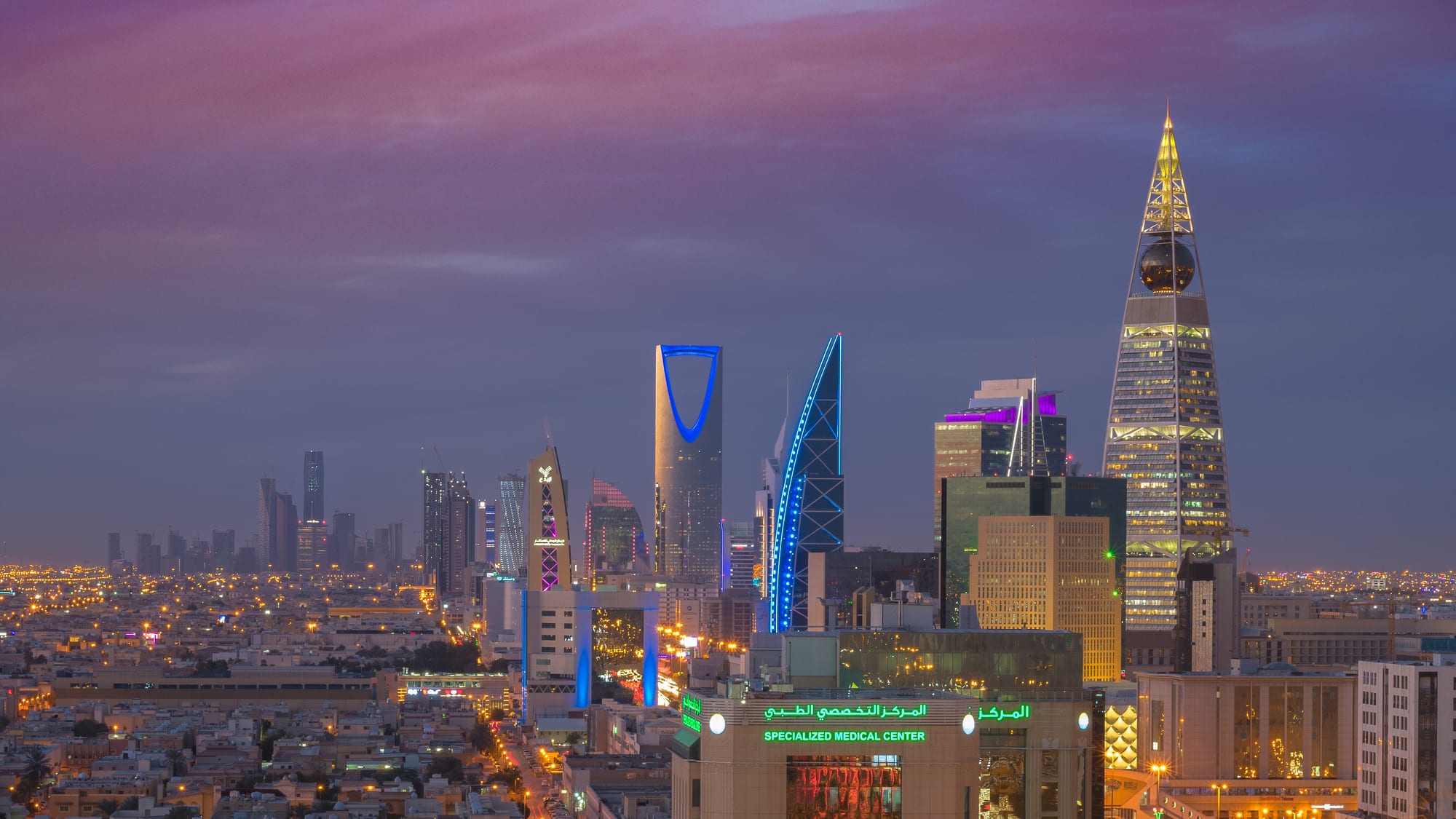 A dense modern city skyline of skyscrapers under a clear sky