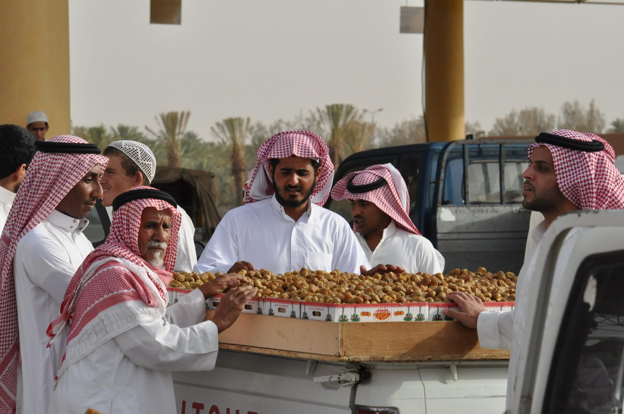 Vendors and buyers examining crates of fresh dates at a market
