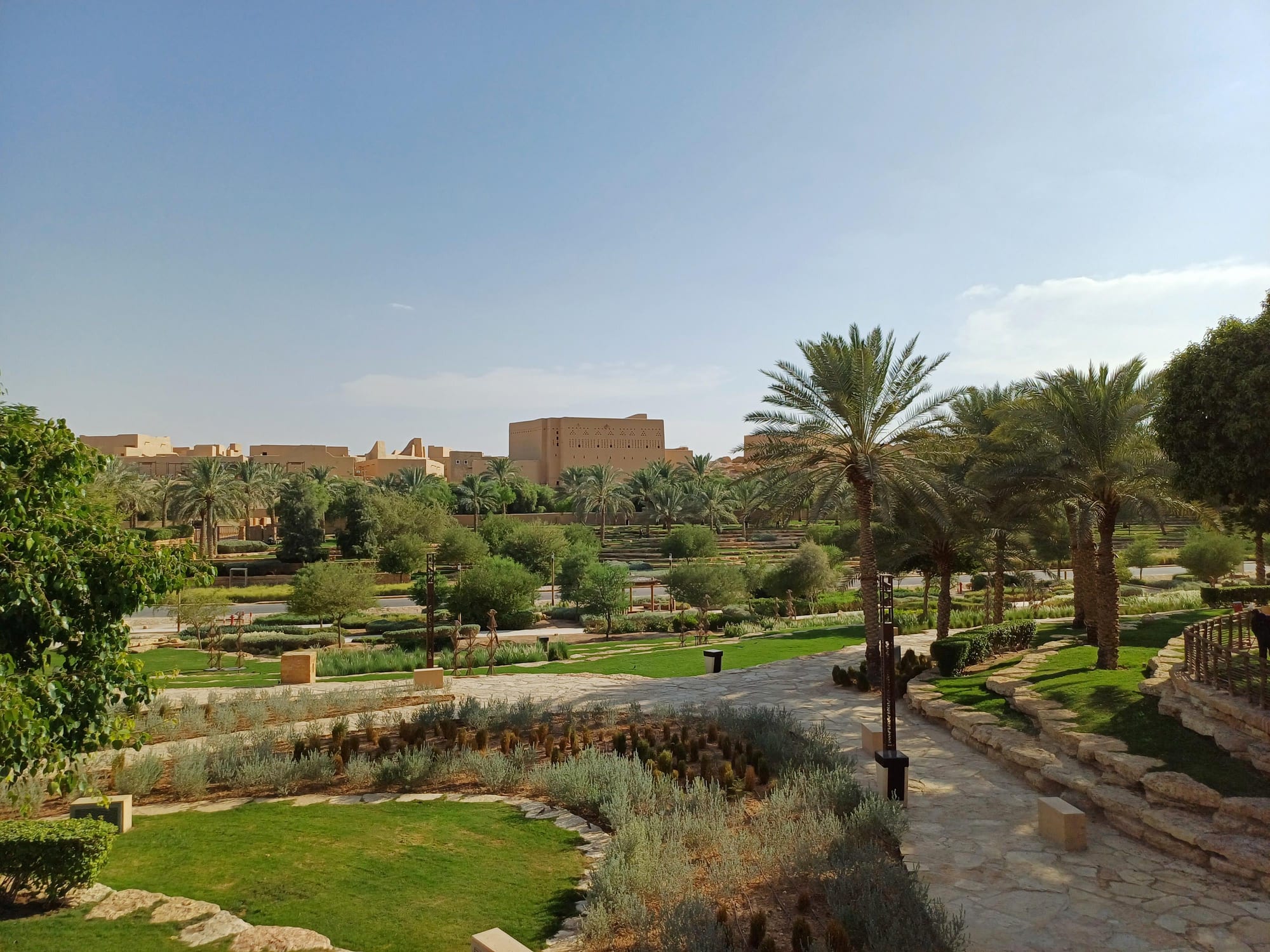 Restored mud-brick palaces and towers of the At-Turaif district at Diriyah, glowing warm against a blue sky