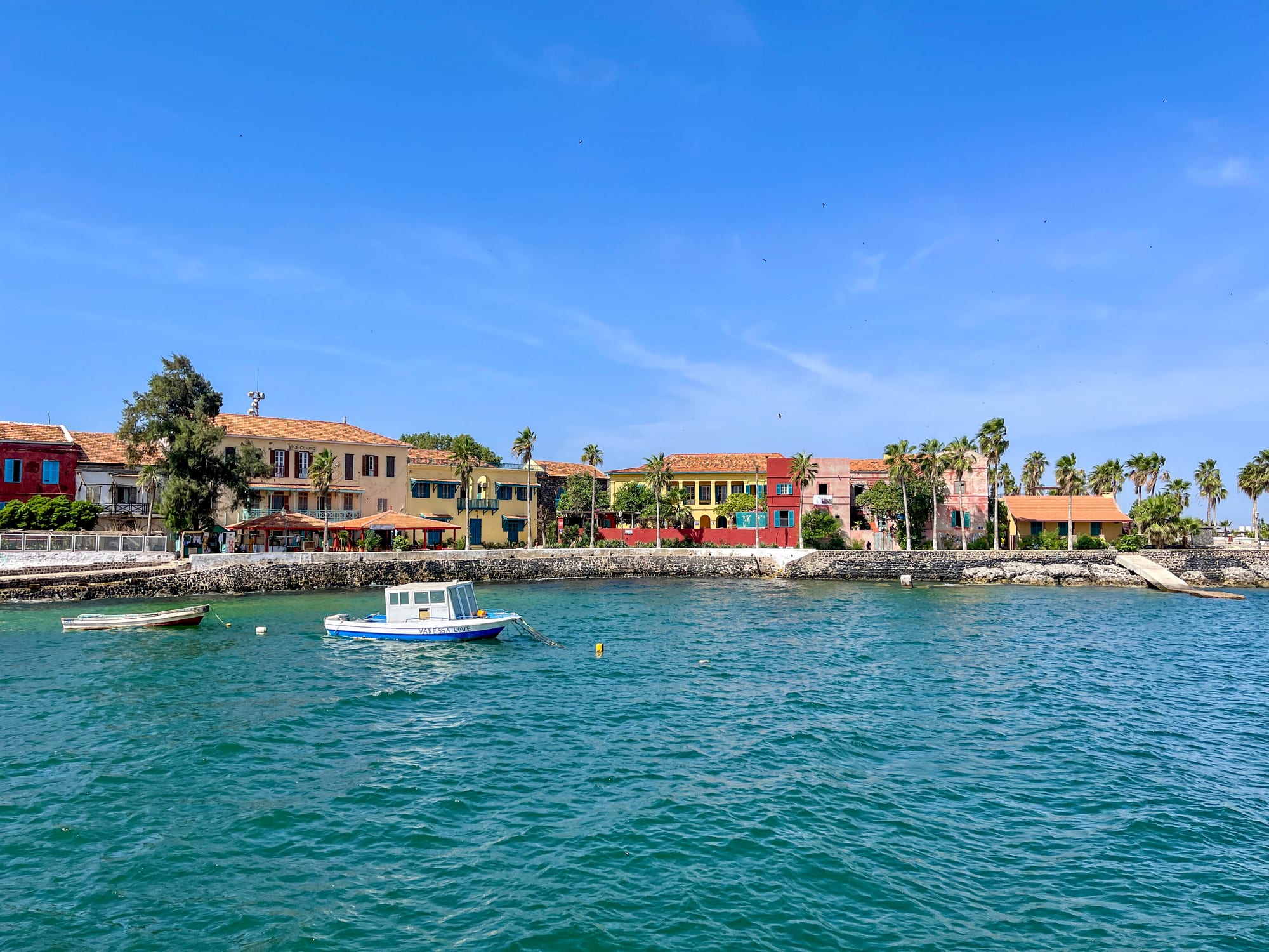 A rocky coastline with colonial-era buildings on a small island