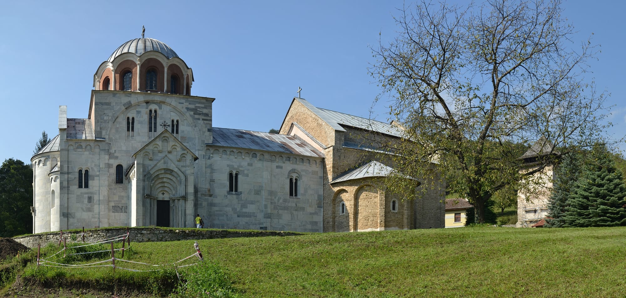 A white marble monastery church within fortified walls