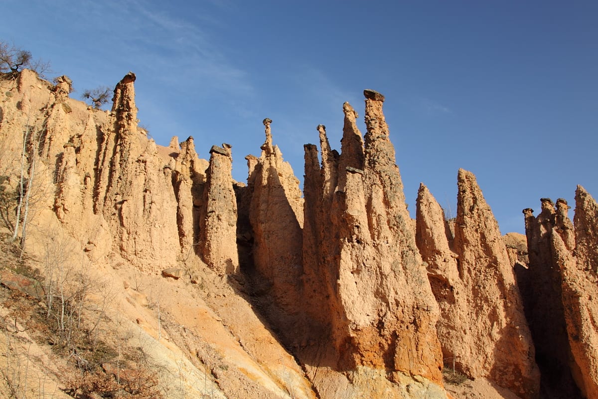 Unusual stone towers each topped with a distinct rock cap, in a barren landscape