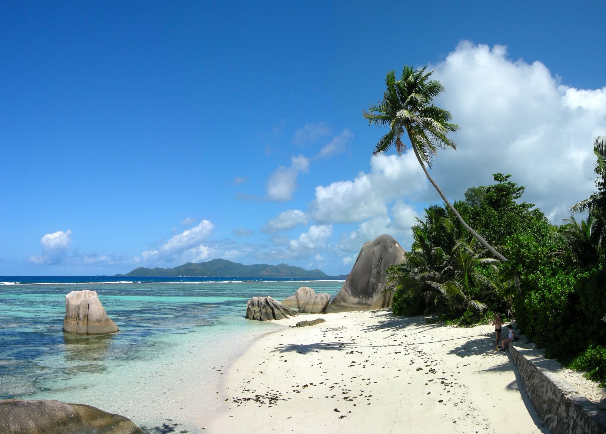 A beach with giant smooth granite boulders and clear turquoise water