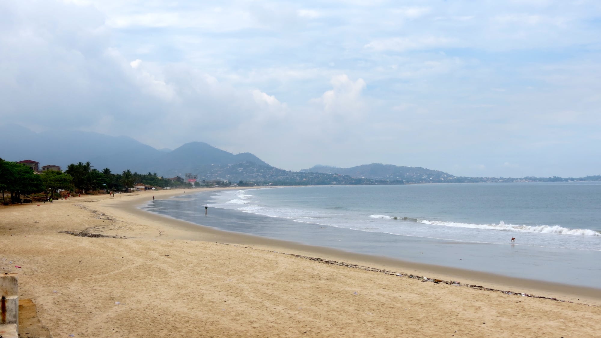 A busy beach with fishing boats along the Freetown coastline