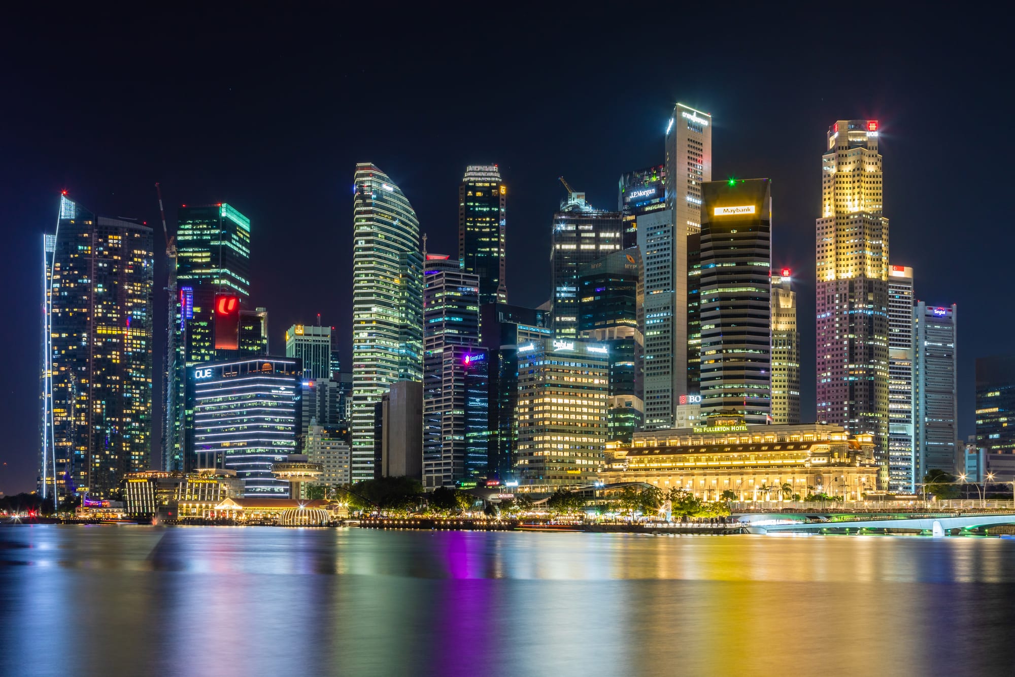 The dense Singapore skyline of high-rise towers behind Marina Bay, with the boat-topped Marina Bay Sands hotel