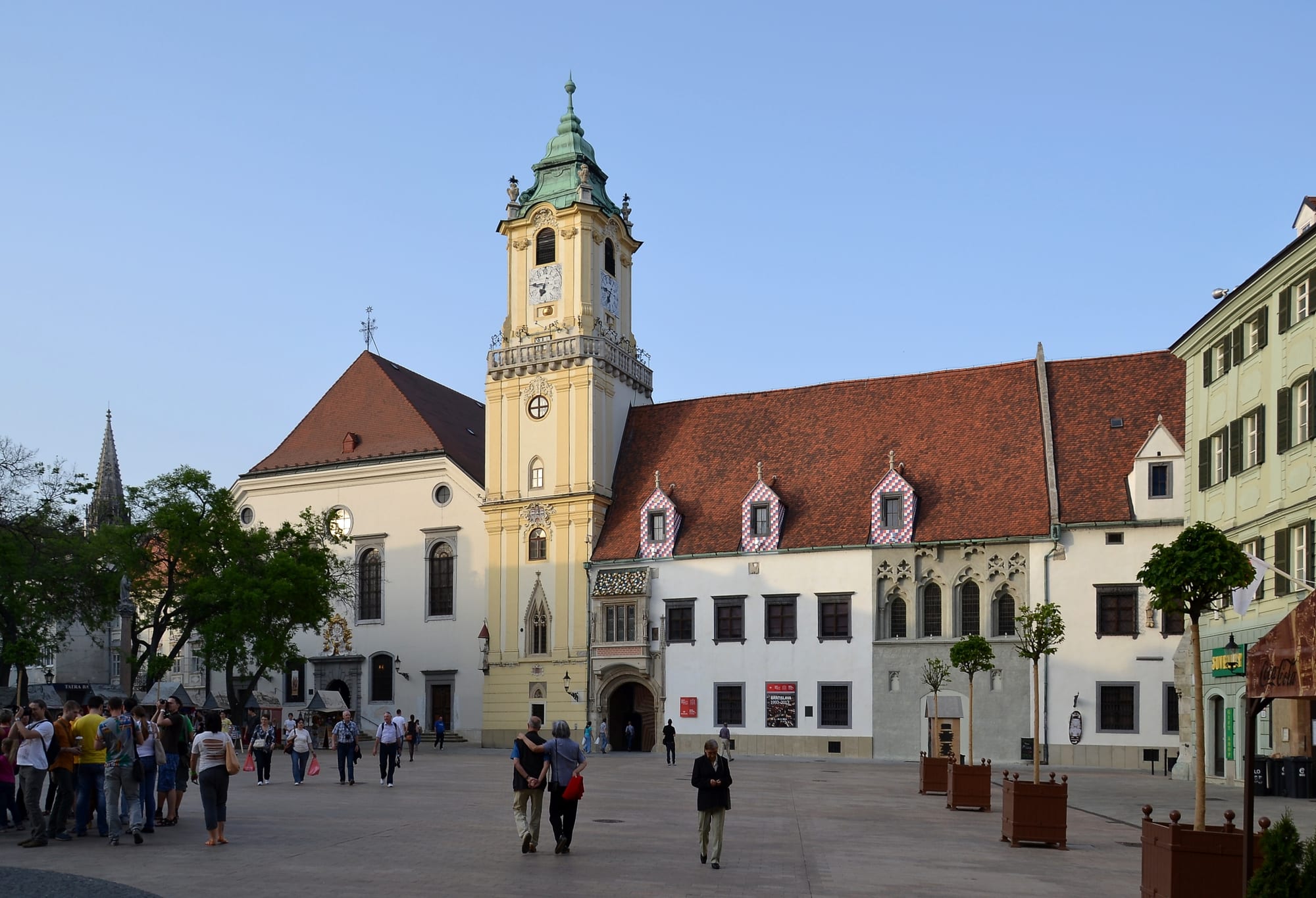 A historic town square with a clock tower and colourful buildings