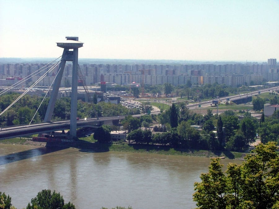 Rows of communist-era concrete apartment blocks (panelák) stretching along the Danube river in Bratislava