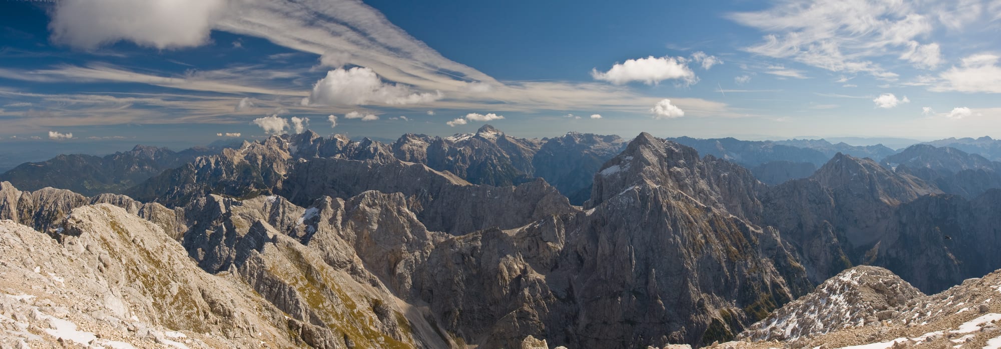 A dramatic view over jagged alpine peaks and green valleys