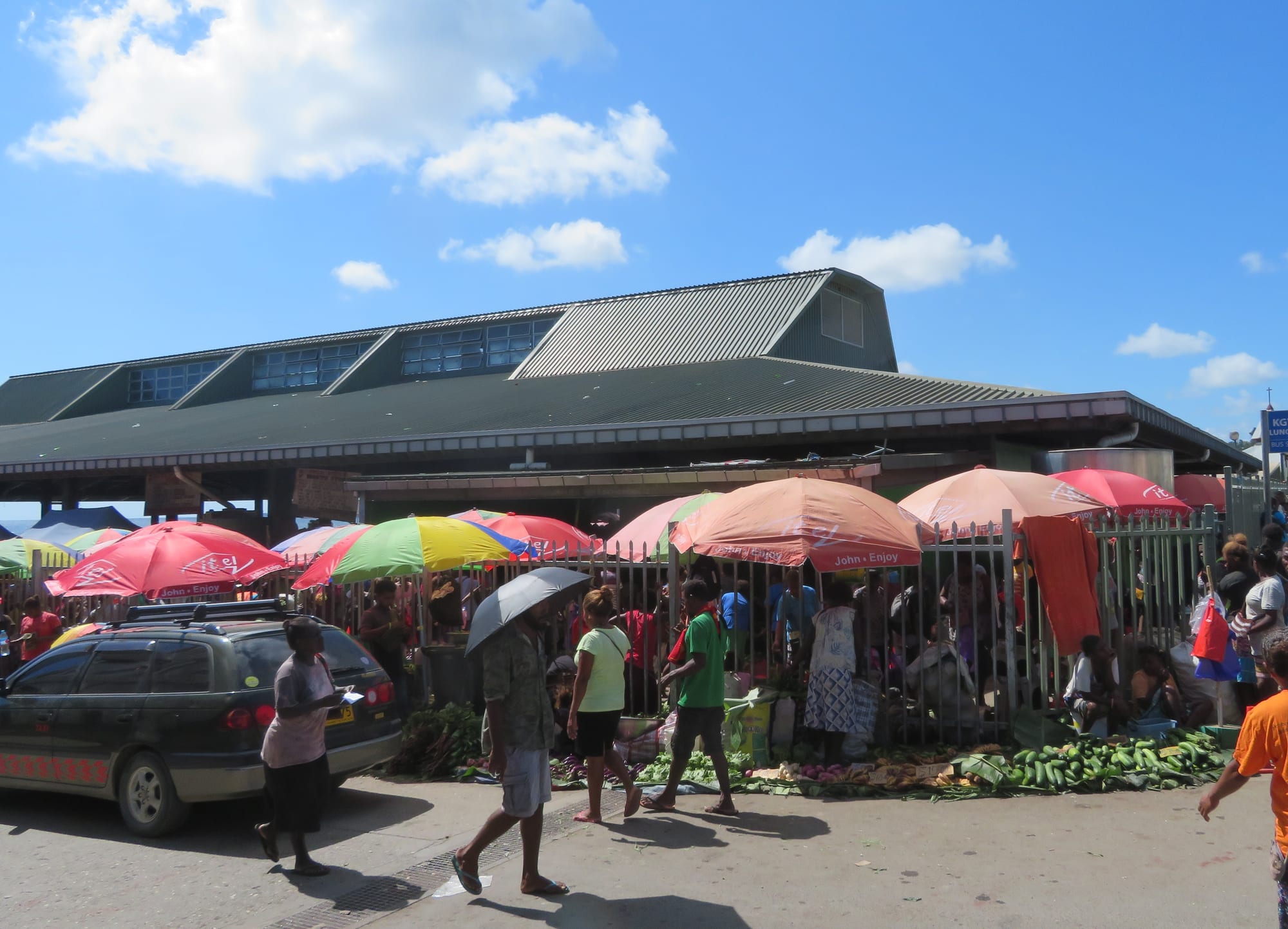 An outdoor market with vendors and produce