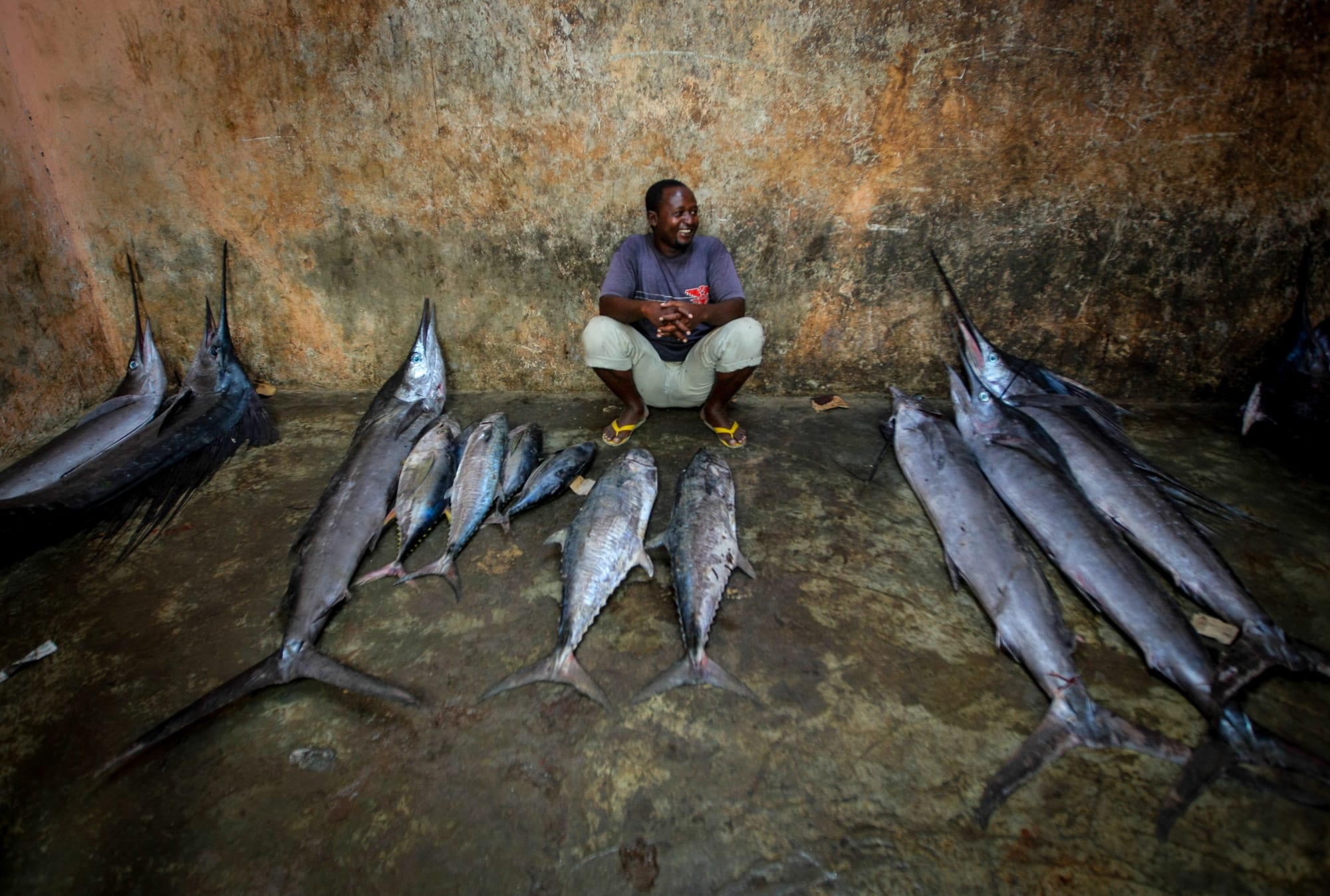 A trader with a large catch of fish laid out for sale