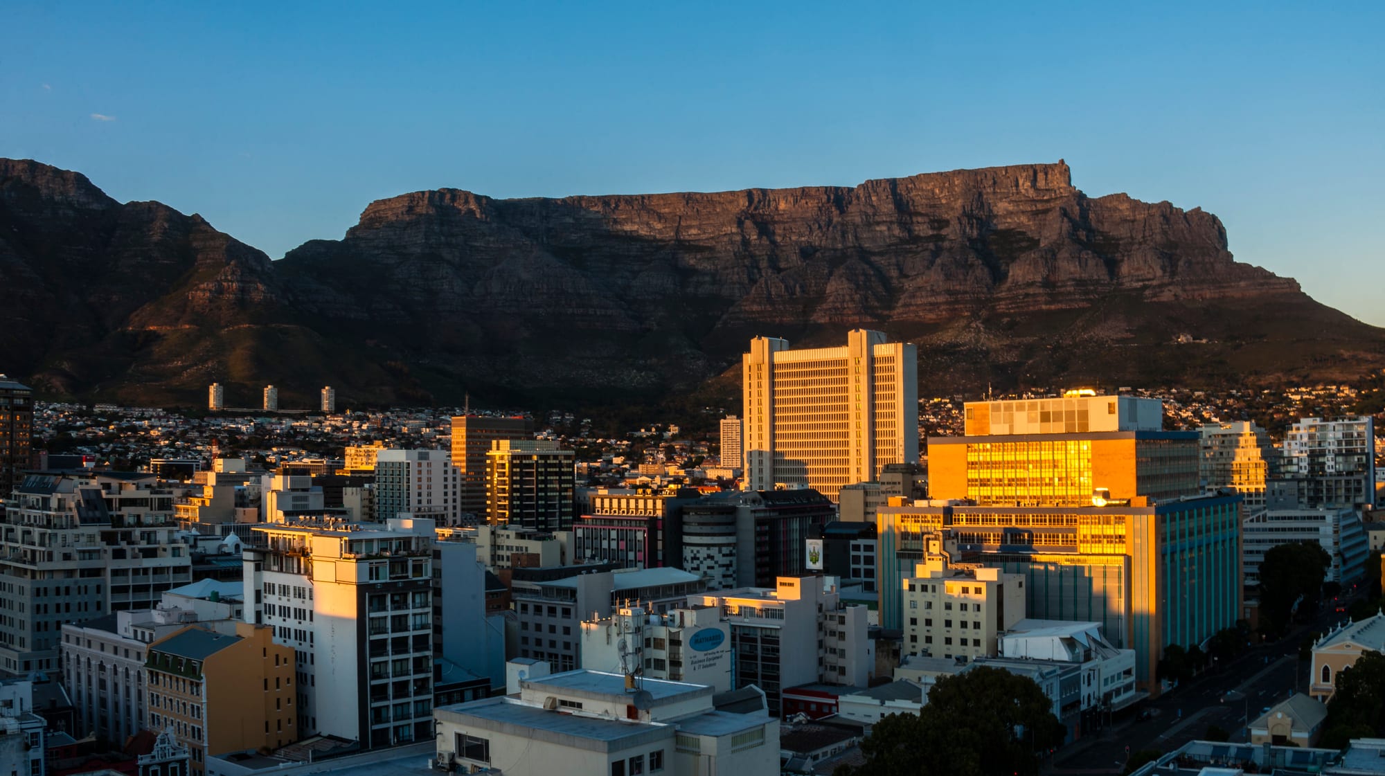 A flat-topped mountain rising above a coastal city