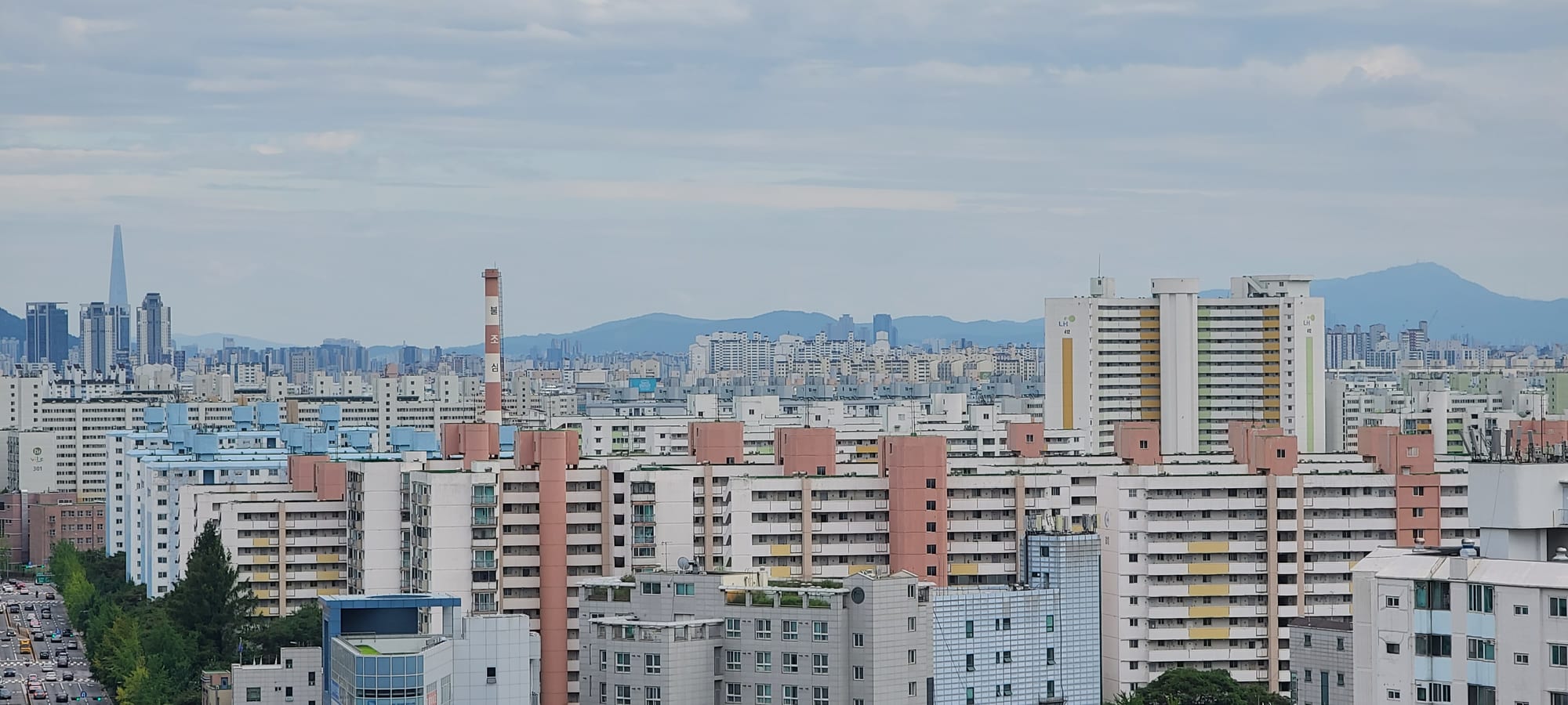 A dense skyline of tall, similar-looking apartment towers stretching to the horizon in a Seoul residential district