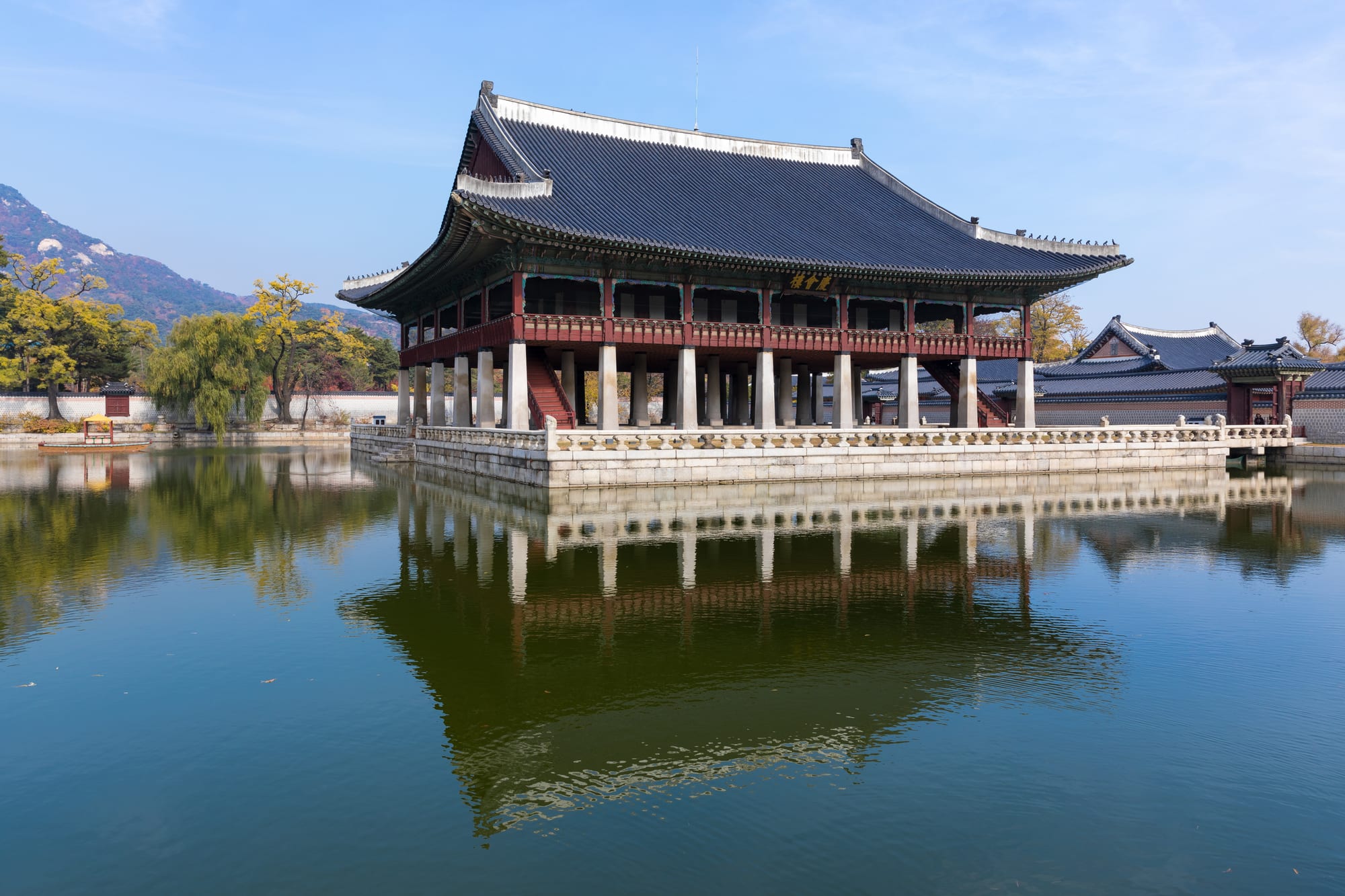 A traditional Korean palace pavilion reflected in a still pond