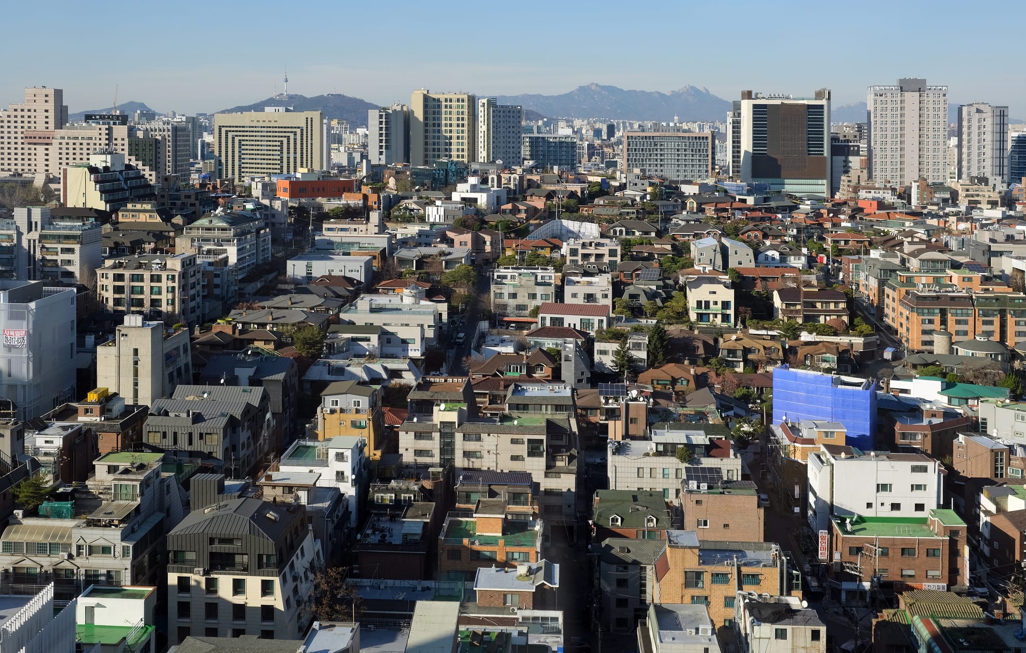 A dense field of glass office and apartment towers stretching to the horizon in the Gangnam district of Seoul