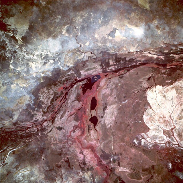 A vast wetland landscape viewed from above, threaded with waterways