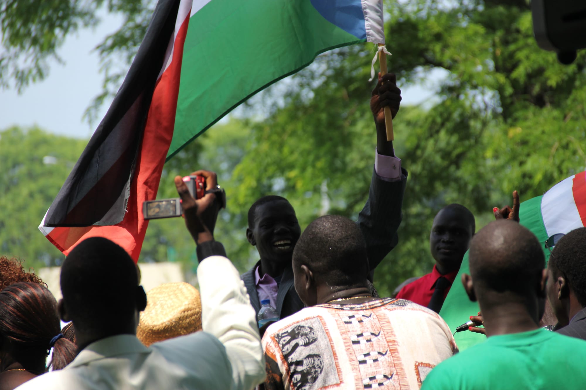 South Sudanese people waving the new national flag at an independence day celebration