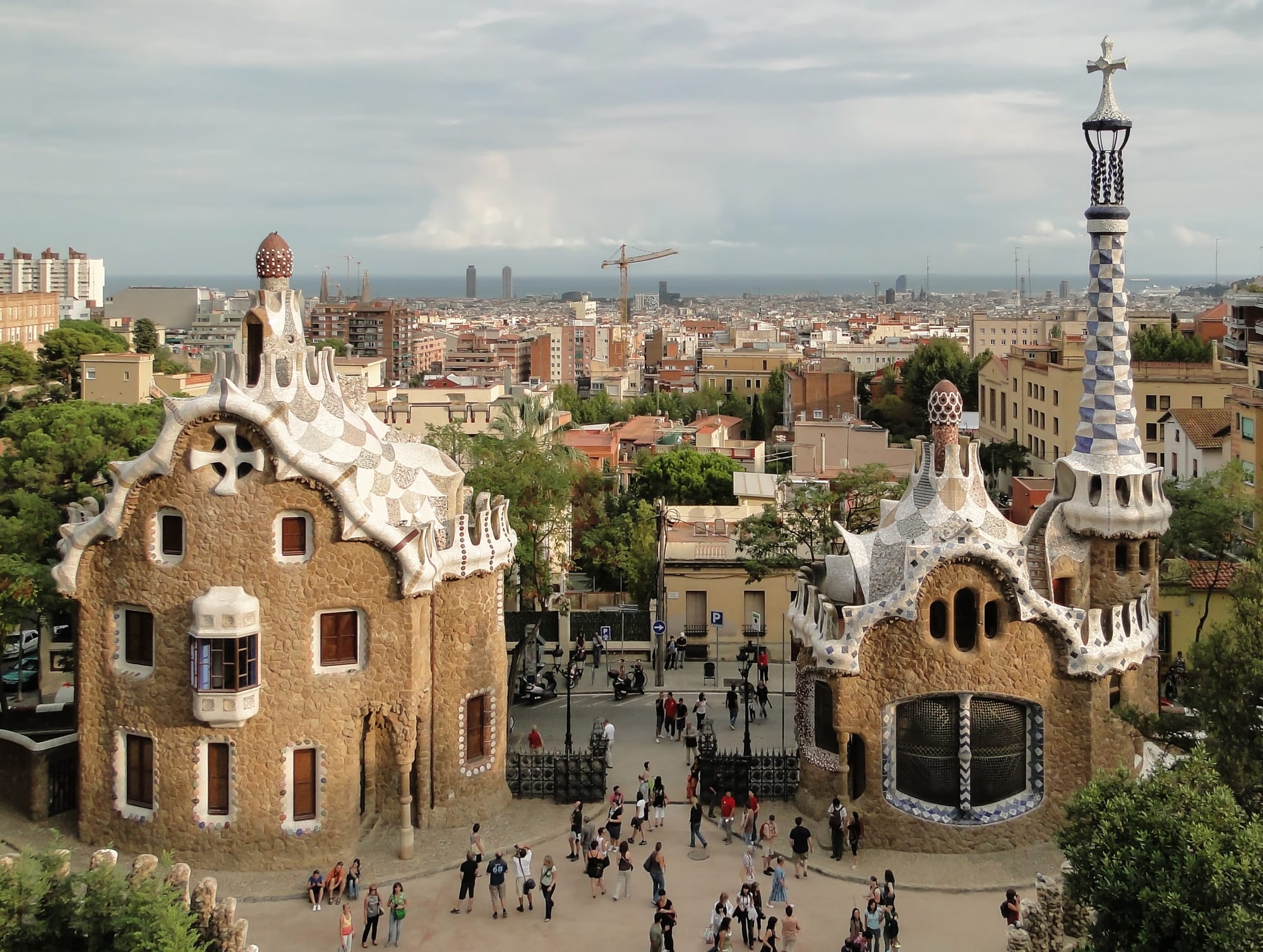 A colourful mosaic-tiled terrace overlooking a city, with whimsical architectural details