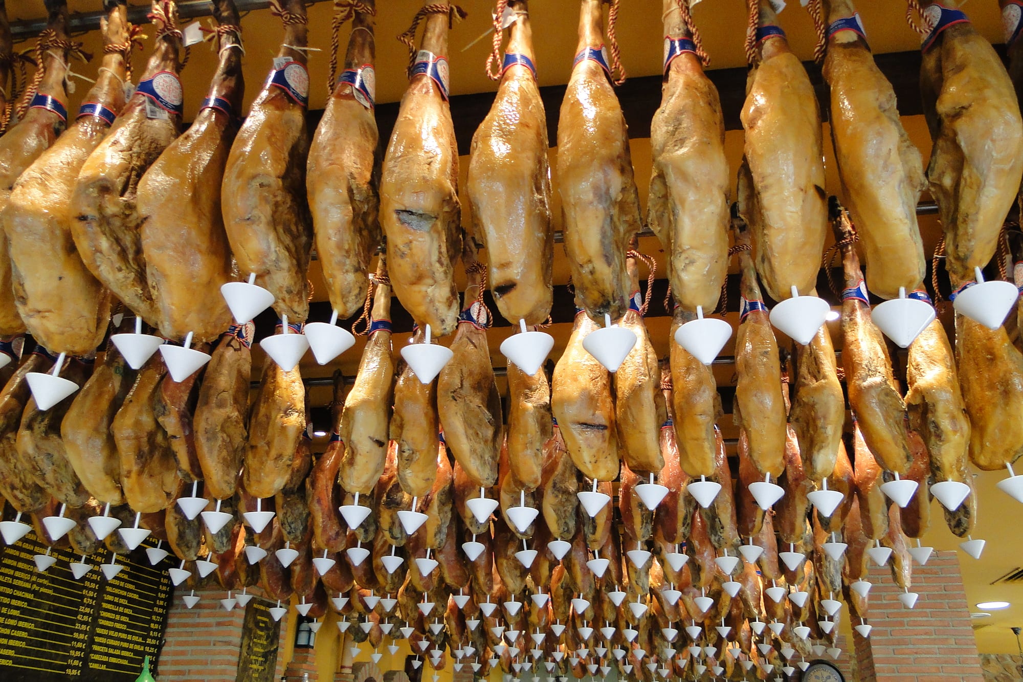 Cured ham legs hanging in a restaurant