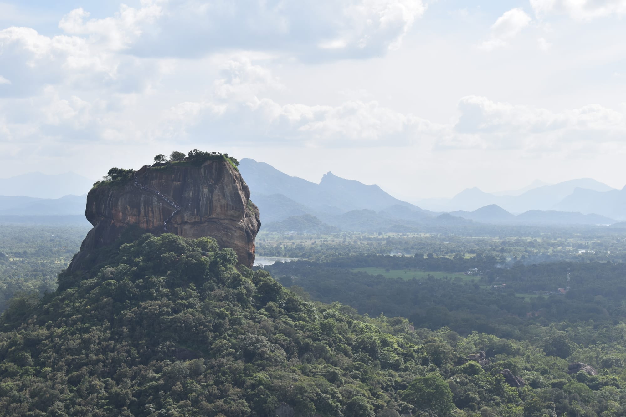 A massive flat-topped rock rising abruptly from dense jungle