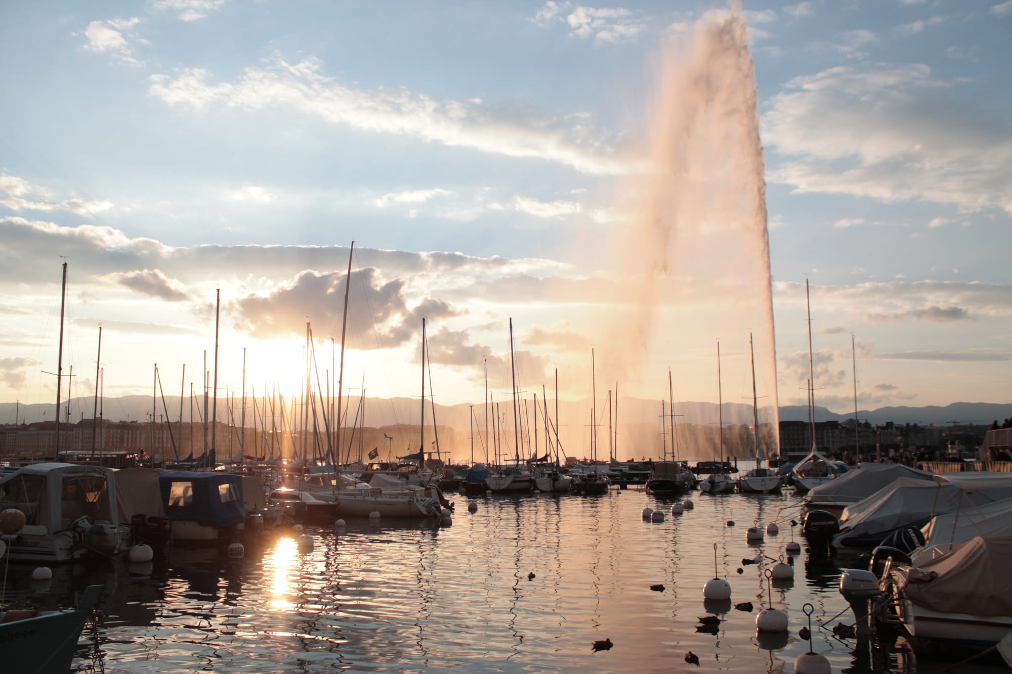 A tall jet of water shooting high into the air above a lake