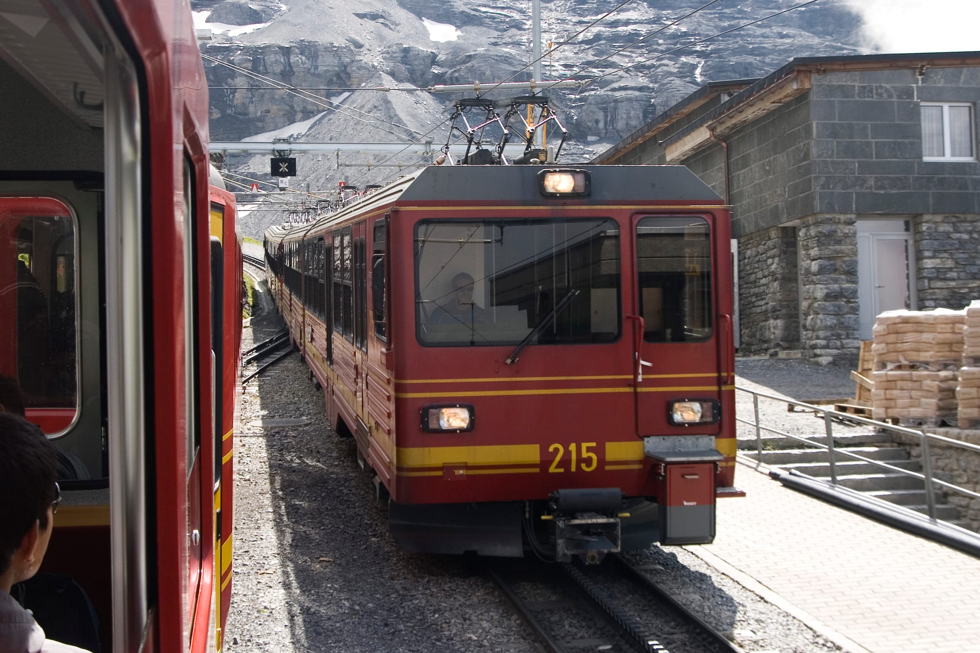 A mountain railway line cutting through snow-covered alpine peaks