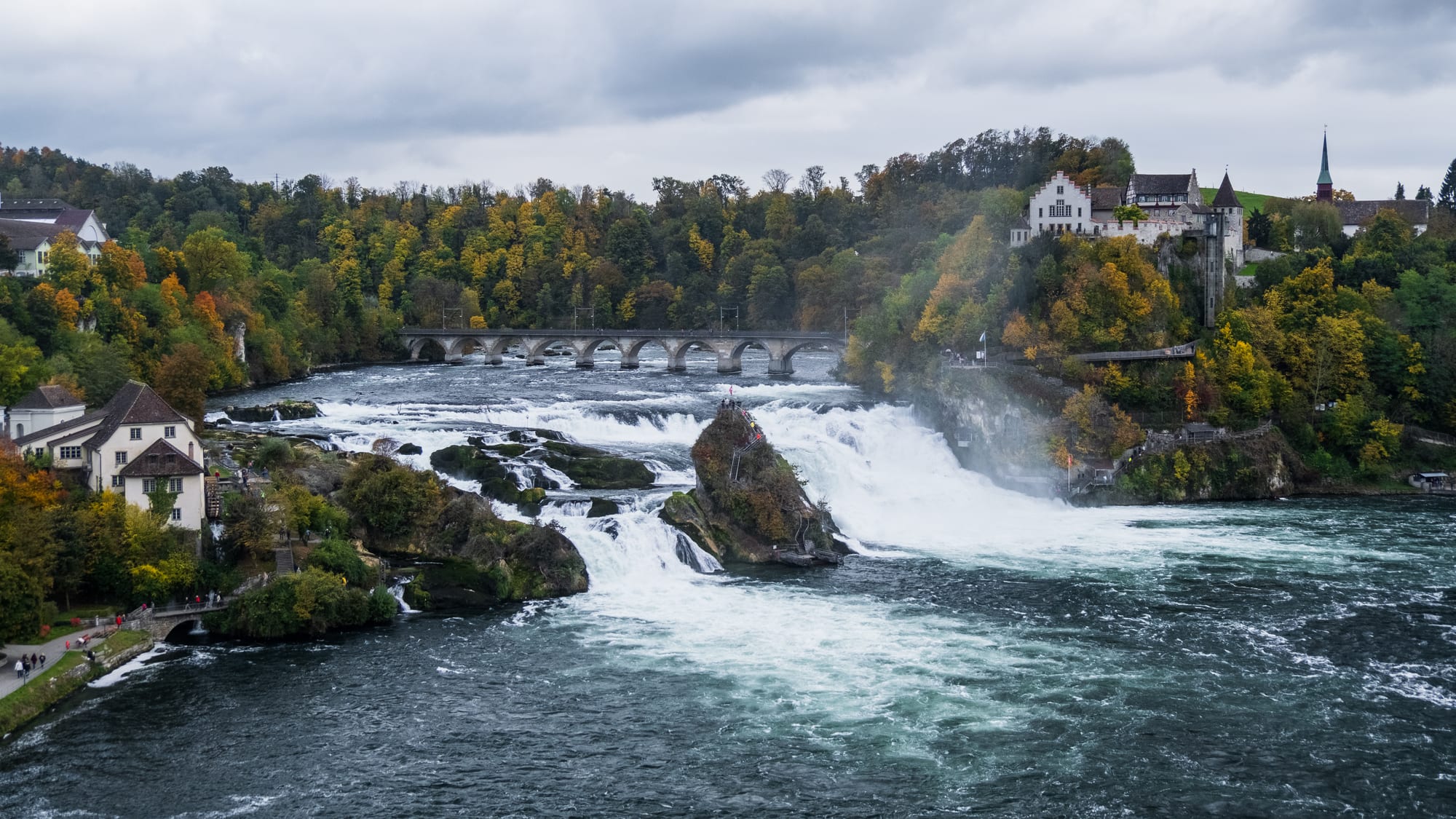 A wide, powerful waterfall crashing over rocks in a river